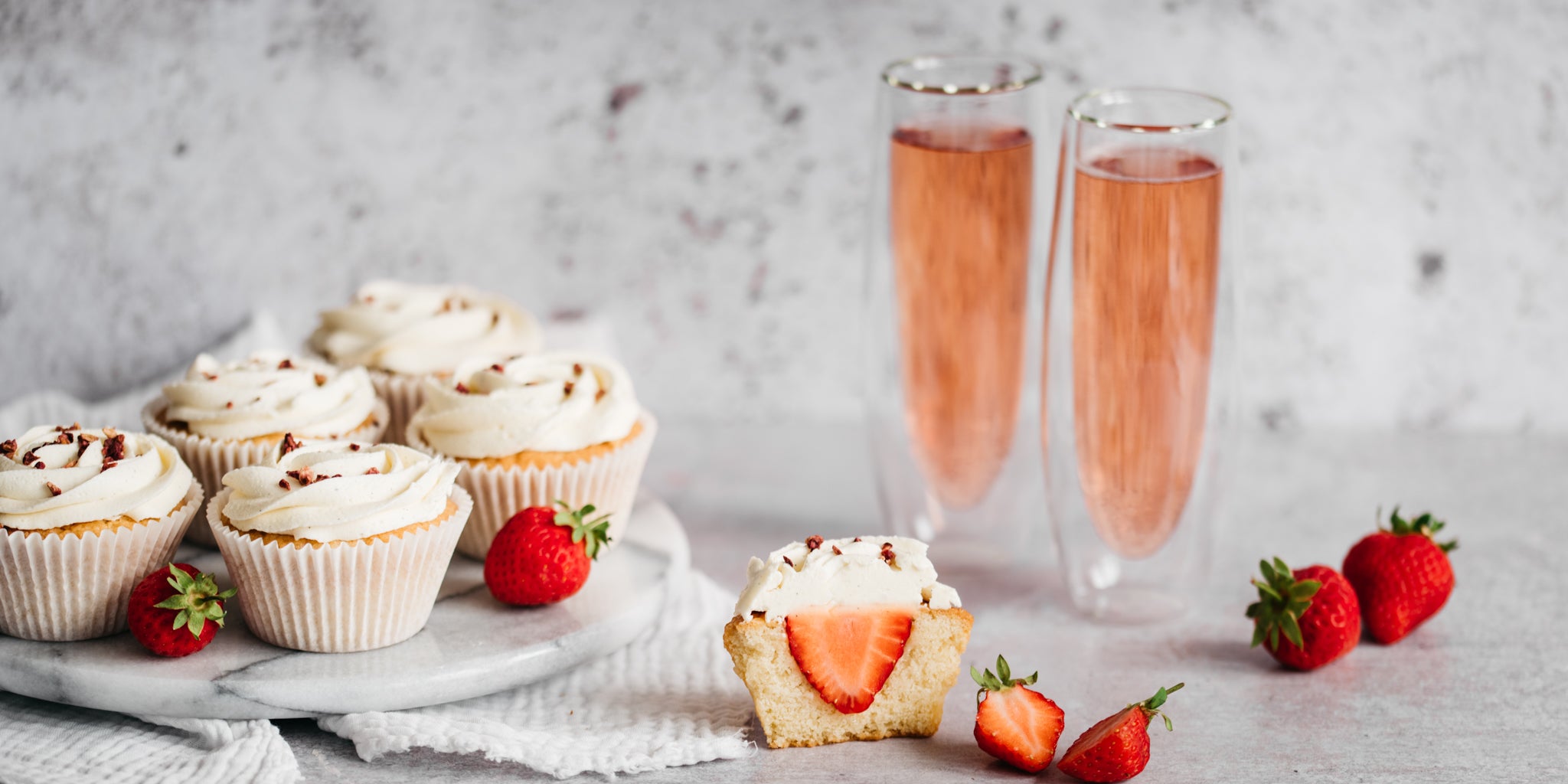 Strawberry & Prosecco Cupcakes next to glasses of fizz
