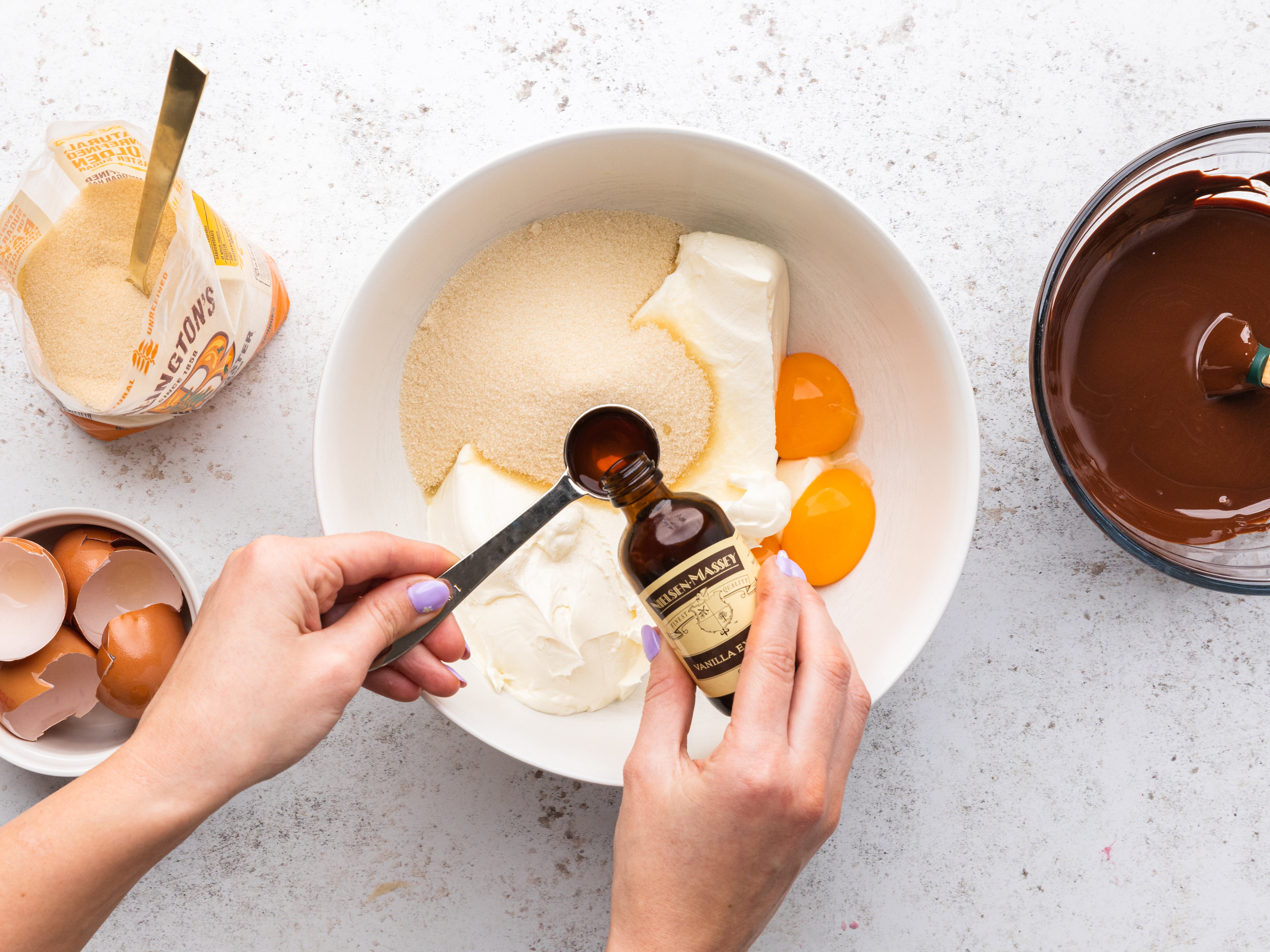 Vanilla Extract being poured into a bowl of ingredients