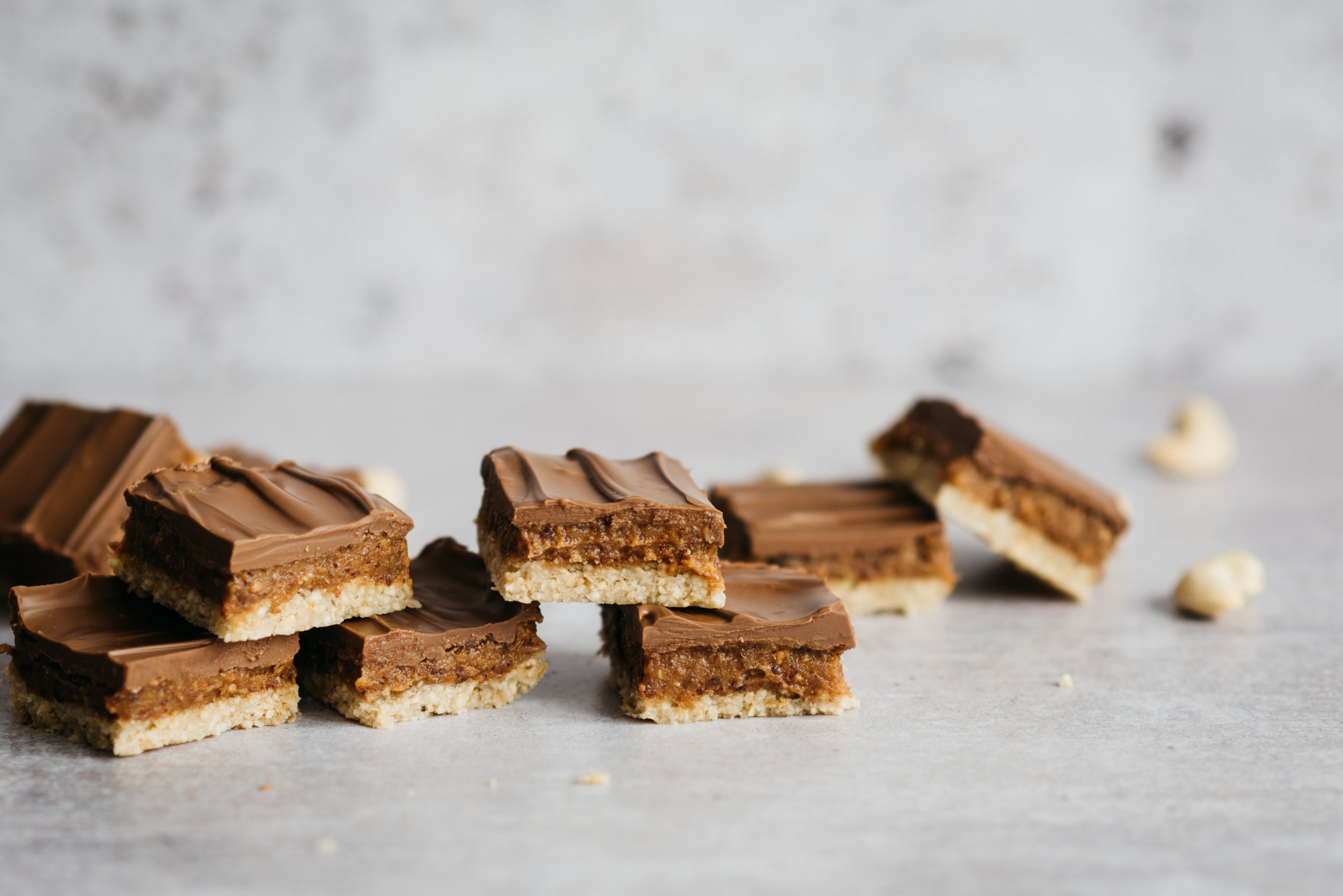 Close up of portions of No-Bake Millionaire Bites stacked up, with a bite taken out of one