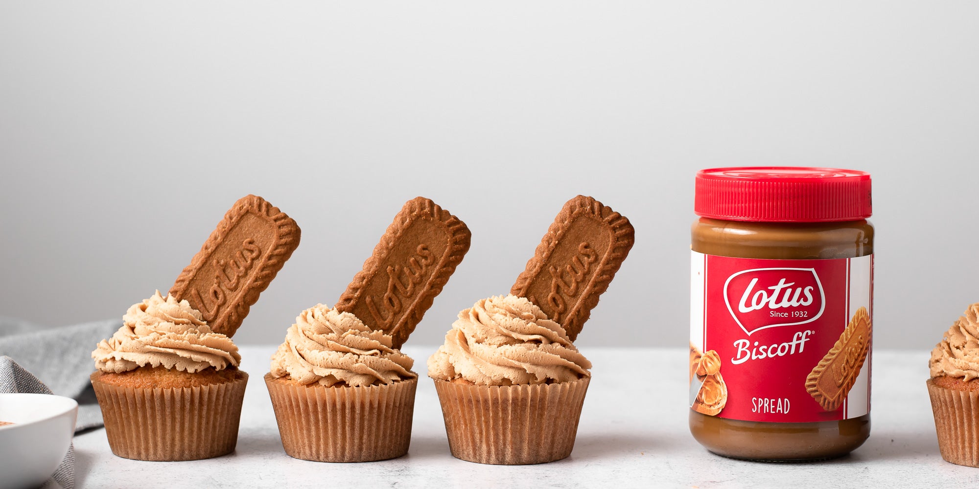 four Biscoff cupcakes next to jar of Lotus Biscoff spread