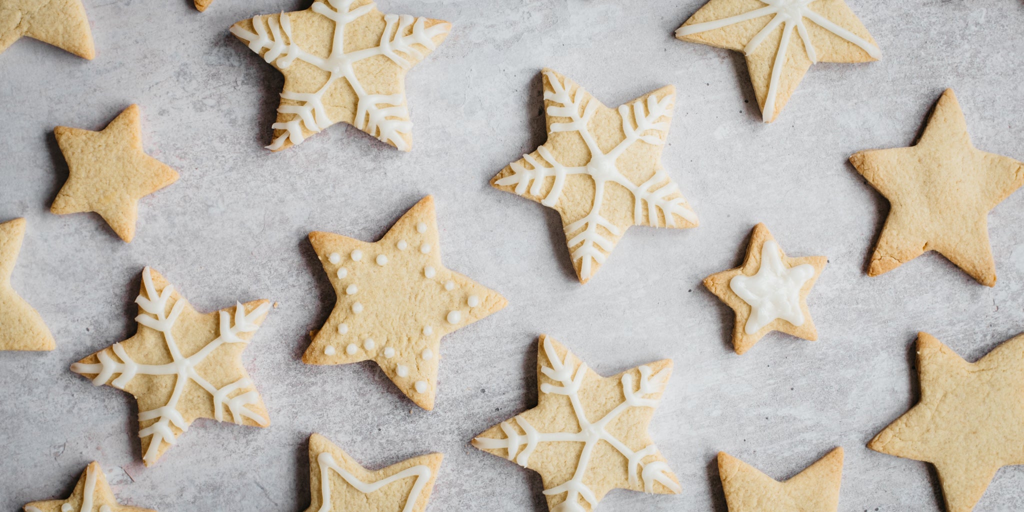 Top down shot of star shaped biscuits piped with white icing in snowflake design