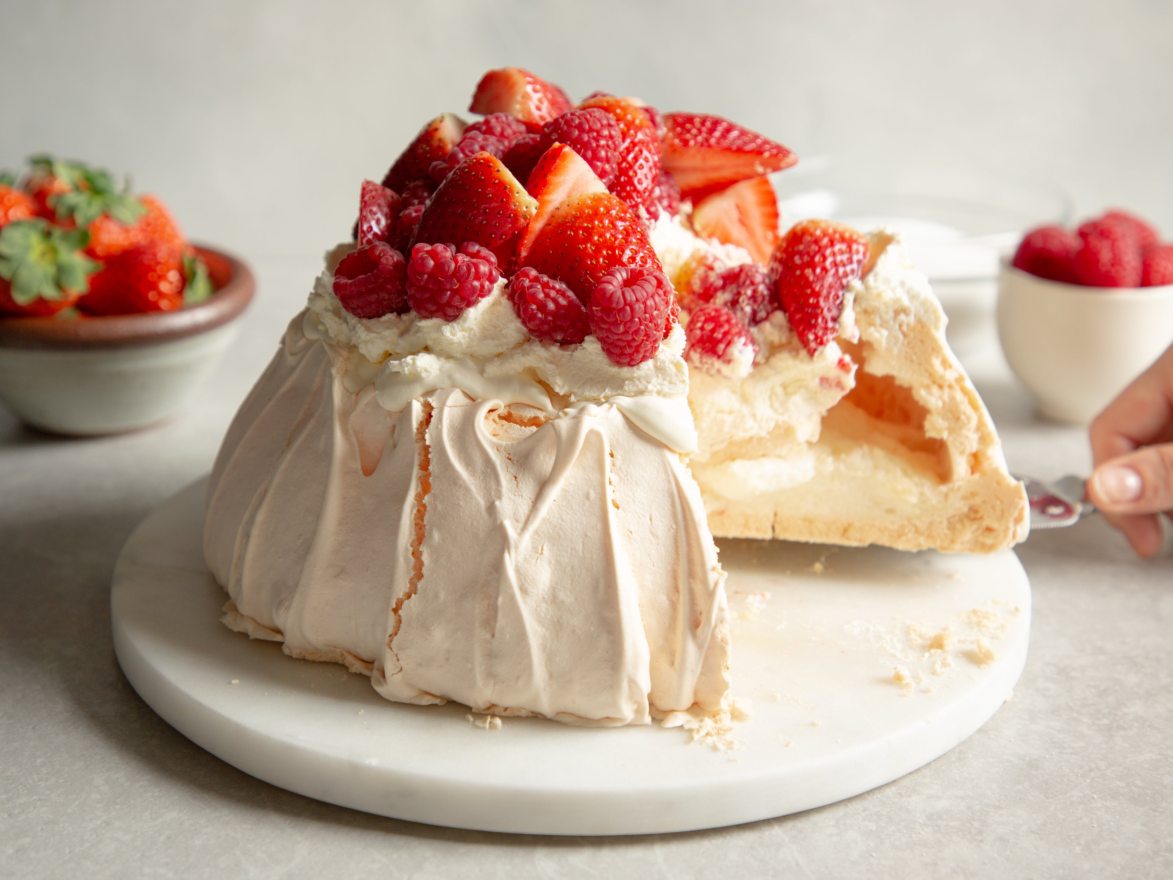 Close up of Strawberry Pavlova with a slice cut out of it showing the chewy, fluffy inside of the meringue
