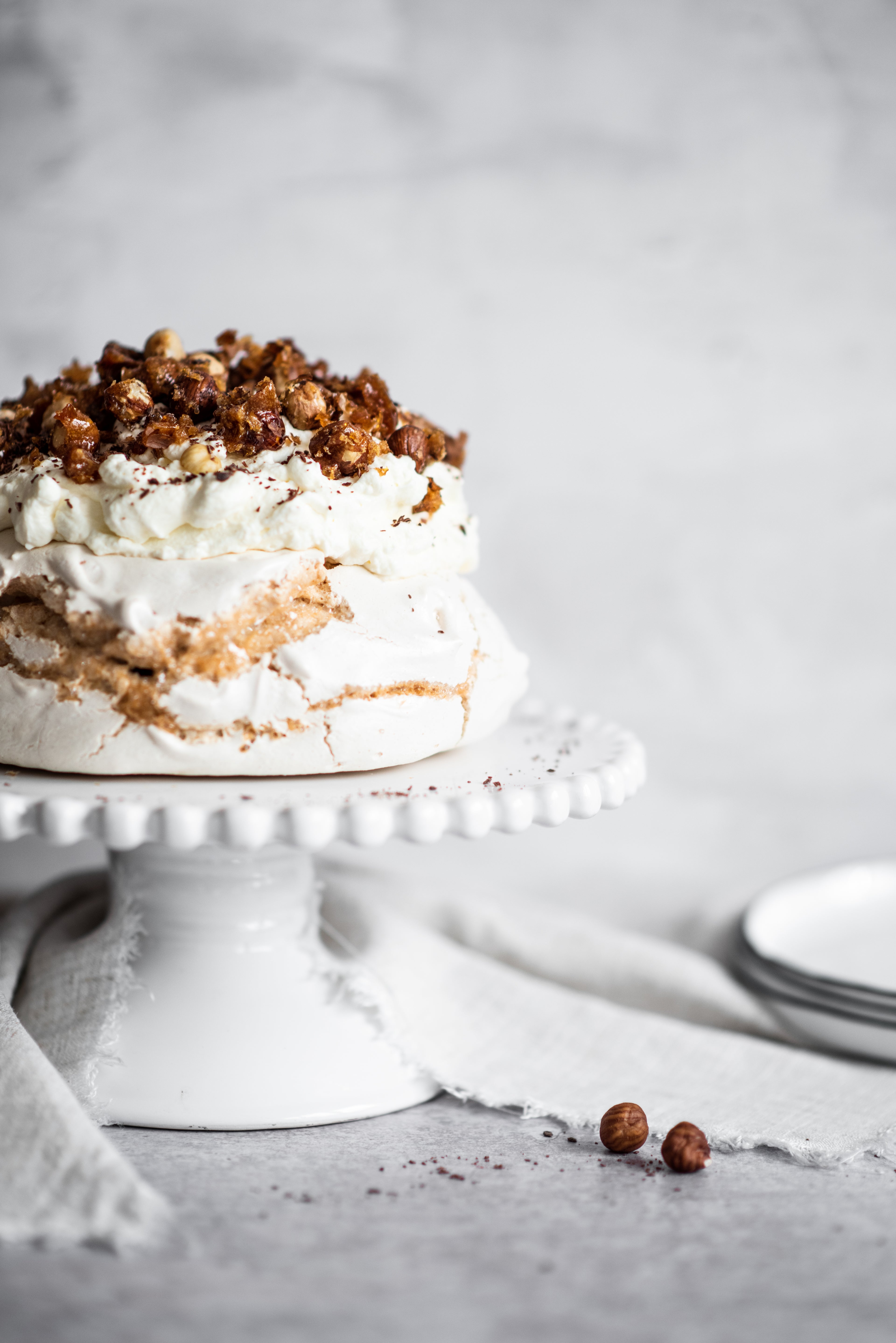 Coffee roasted hazelnut meringue on stand topped with hazelnuts