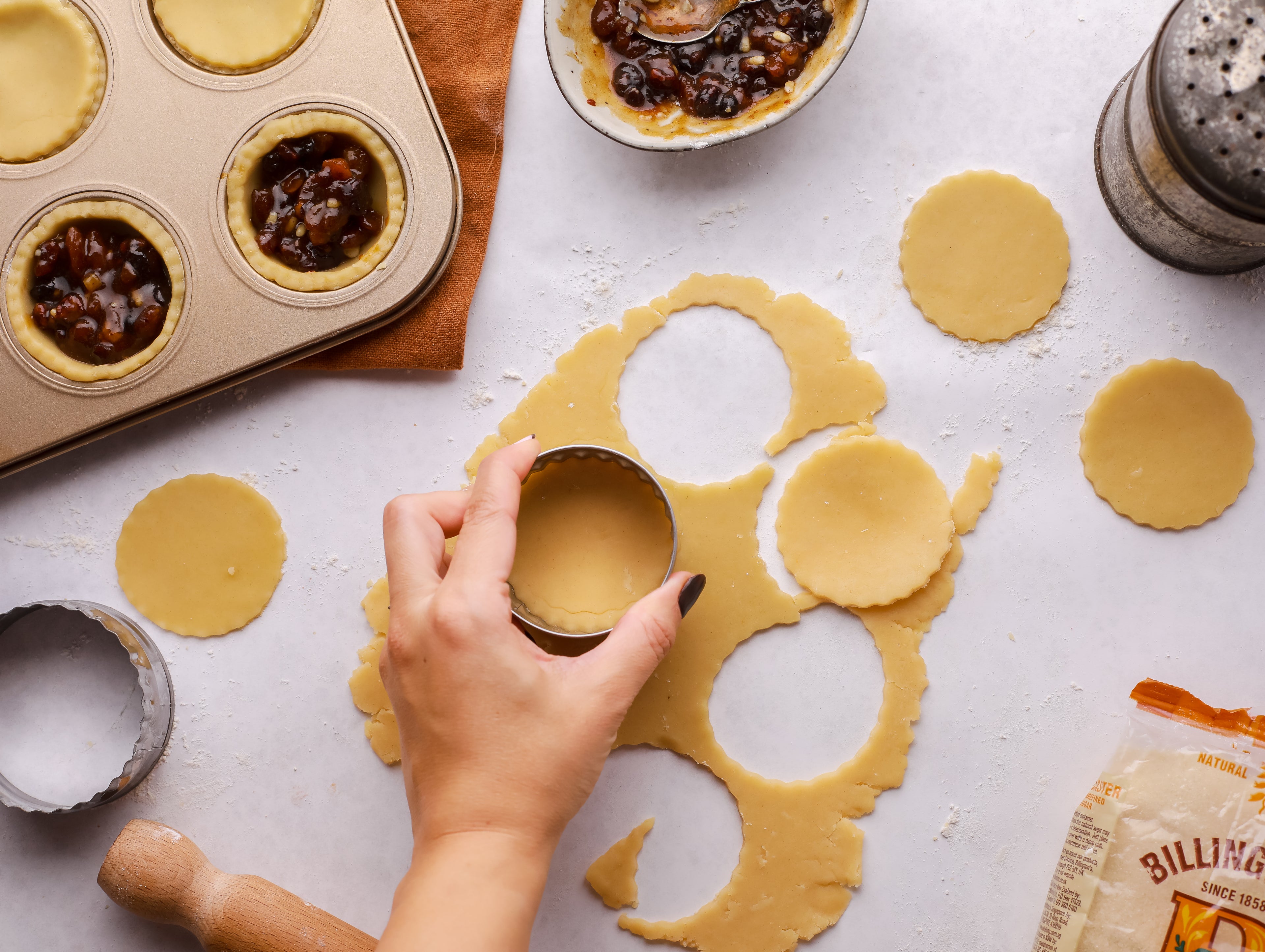 Hand cutter out circular rounds of pastry for mince pies