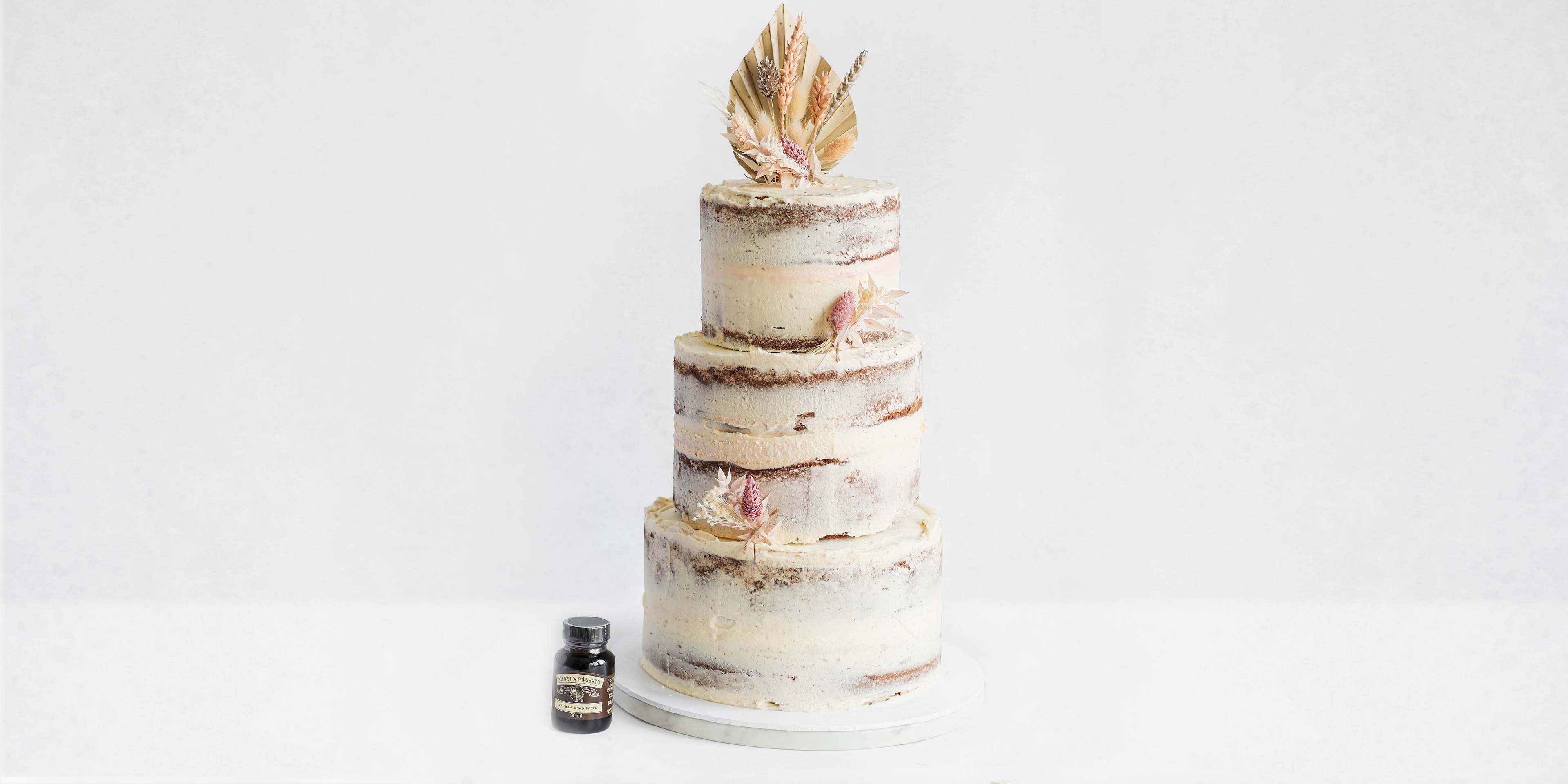Side on view of a three tiered naked vanilla celebration cake