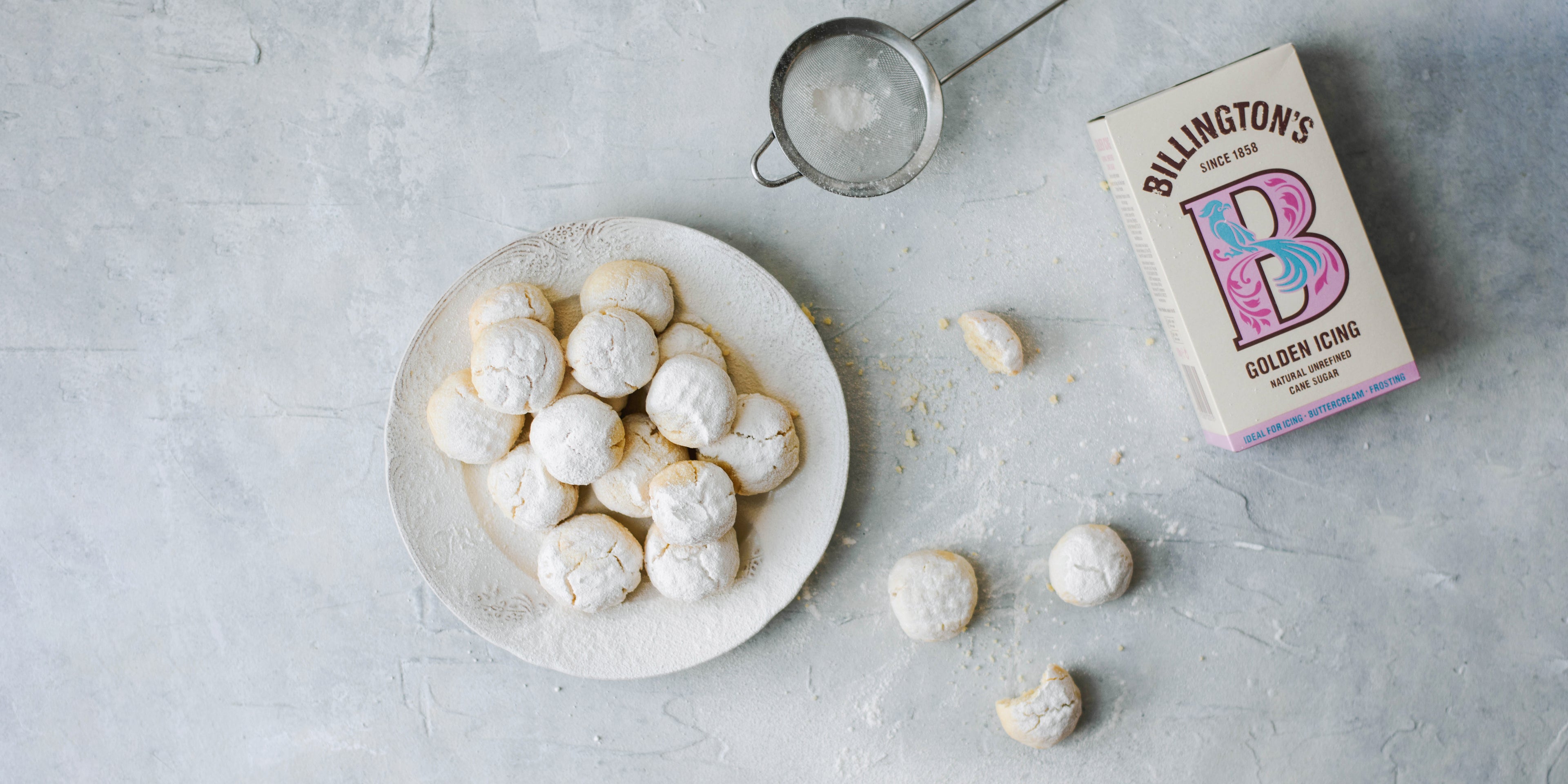 Kahk Eid on a plate with sieve and box of Billington's golden icing sugar