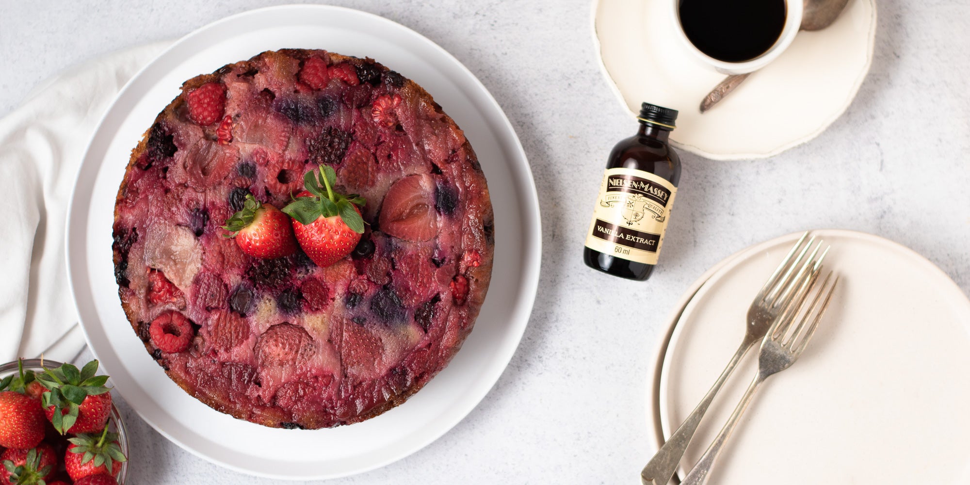 upside down berry pudding on a plate topped with two strawberries