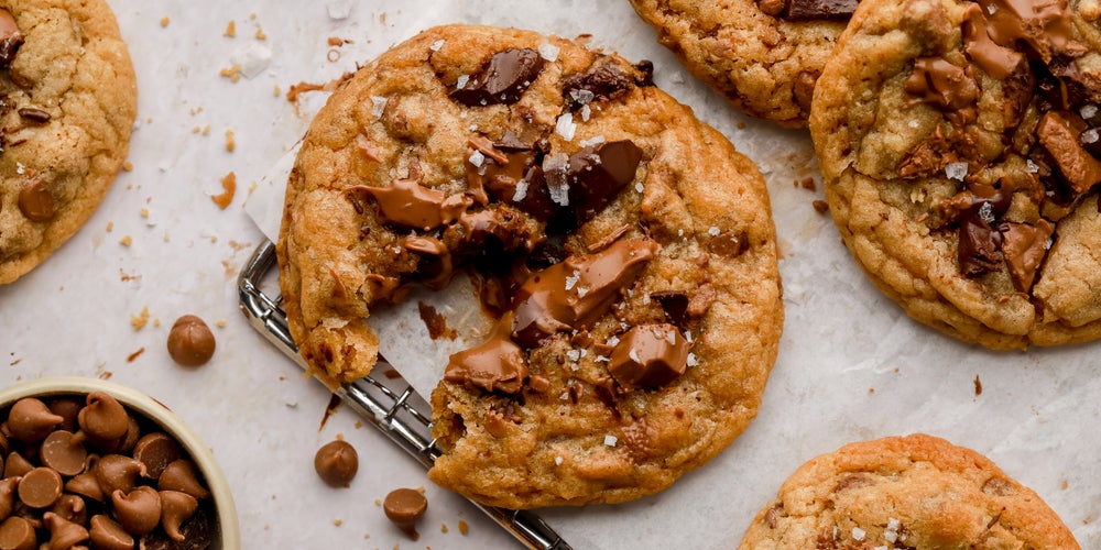 Broken homemade Millie’s cookie with chocolate chips and salt sprinkled on