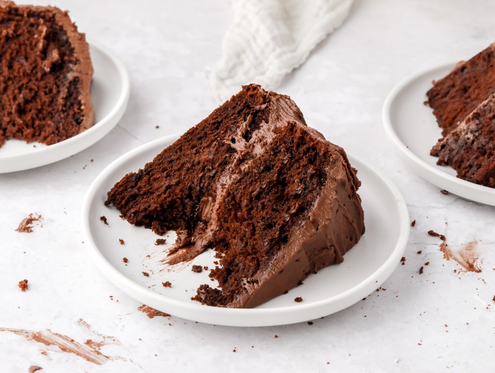 Chocolate cake on a white plate with bite missing