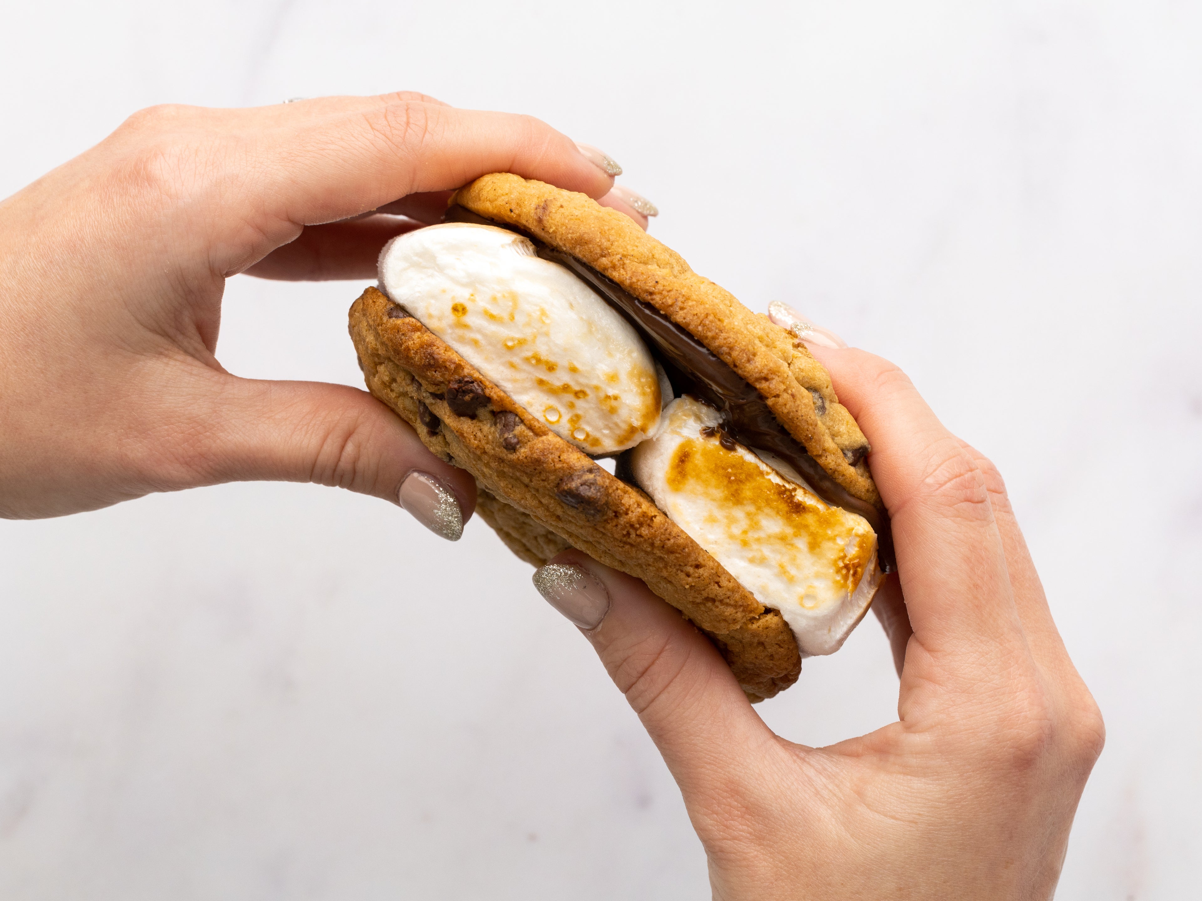 Hand holding a smores cookie sandwich