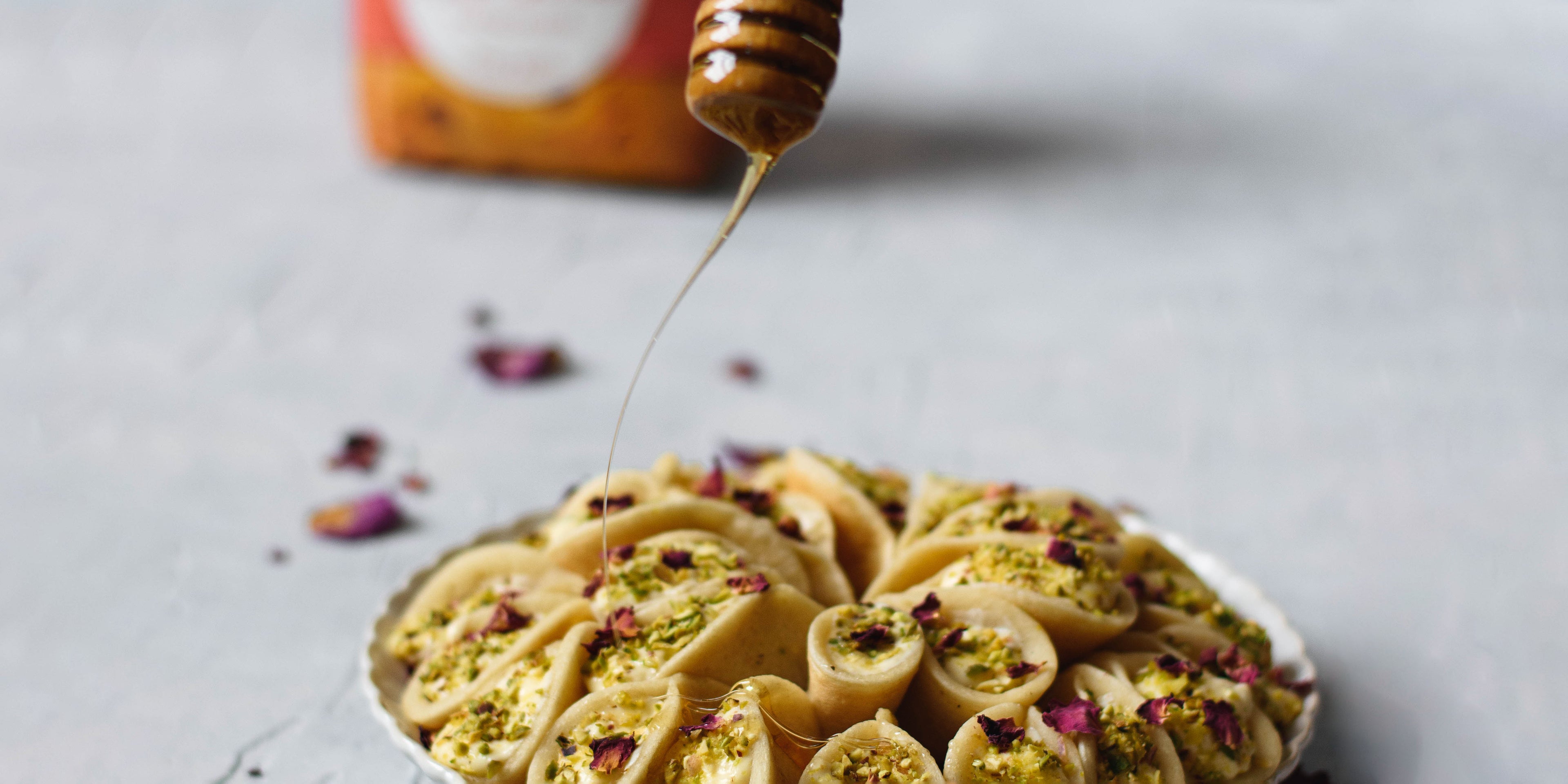 Qatayef being drizzled with honey