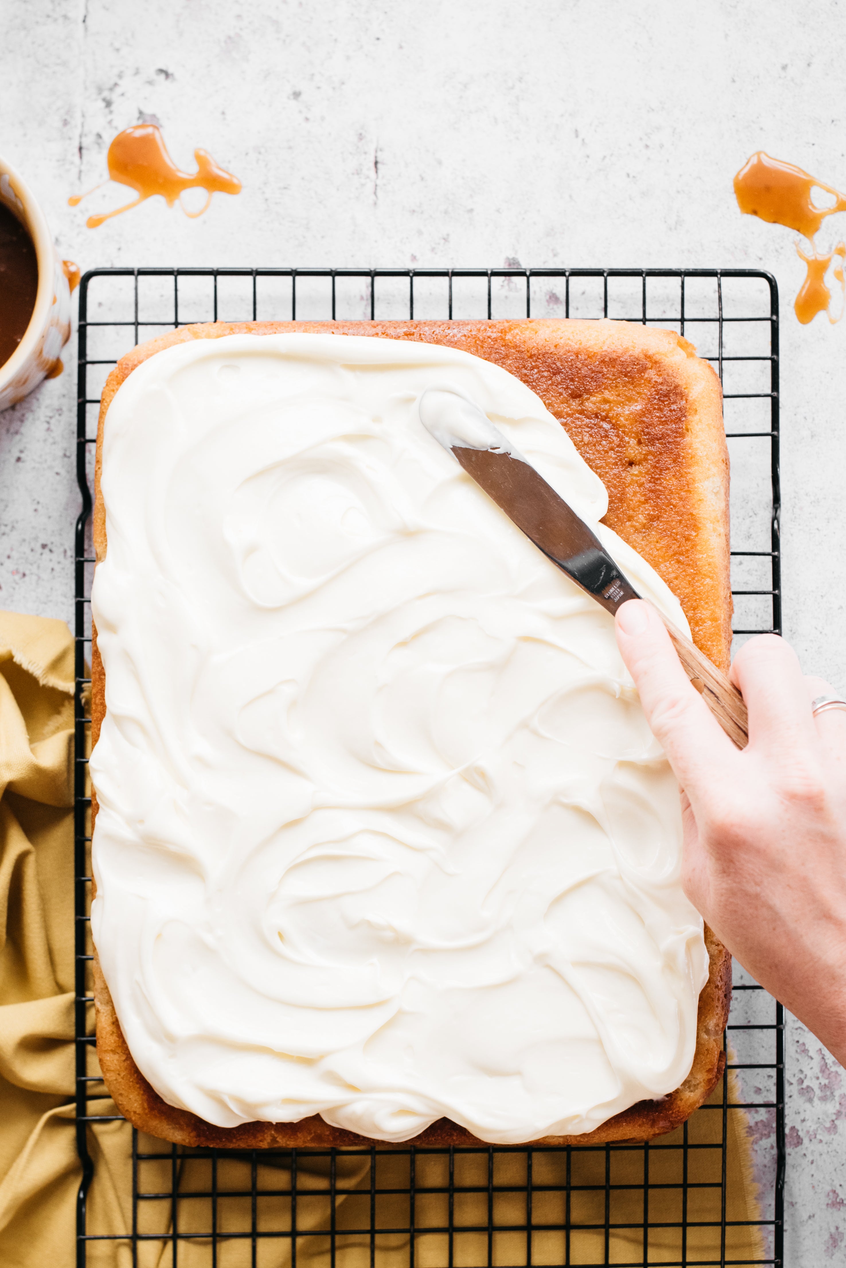 Hand spreading buttercream on cake