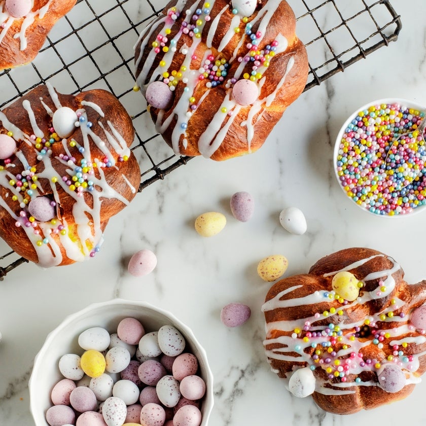Easter bread drizzled with white icing and topped with chocolate mini eggs