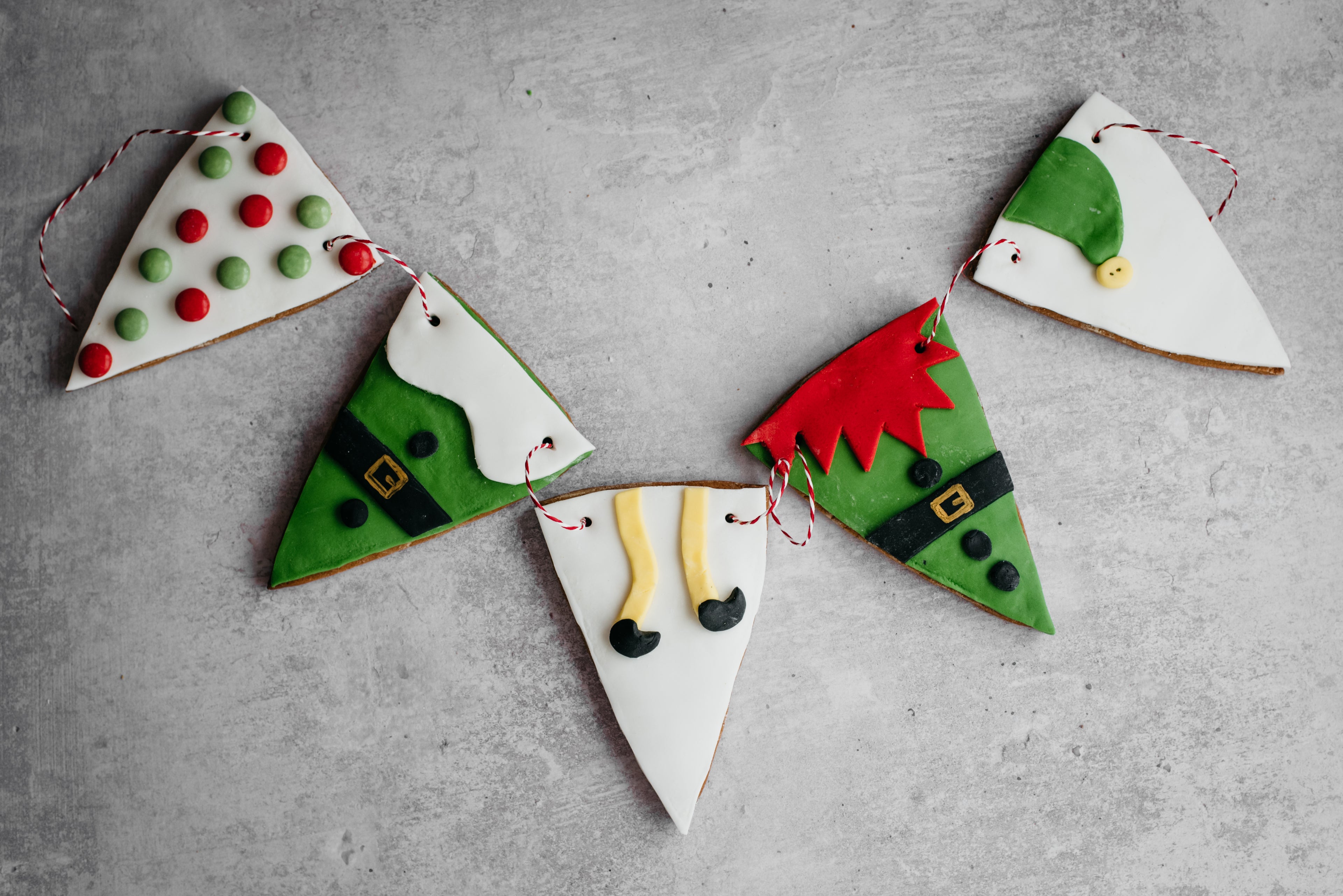 HoHoHo Elf Bunting close up, decorated with elf designs threaded together with red and white twine