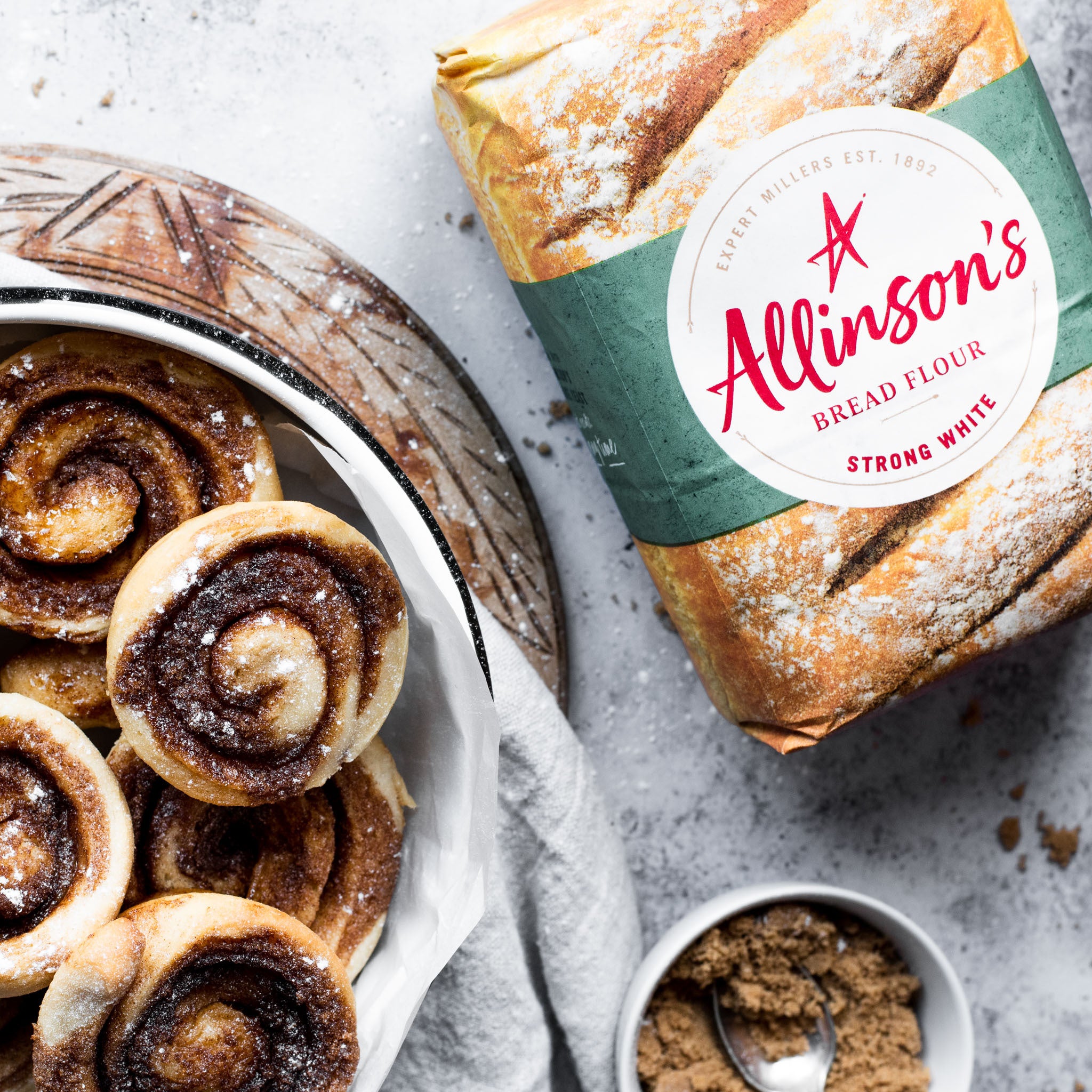 Plate of cinnamon rolls sprinkled with icing sugar