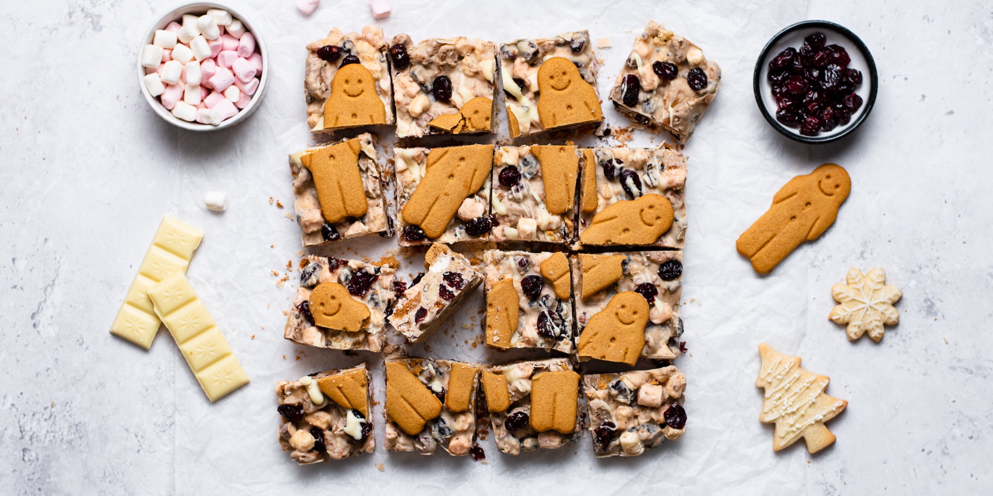 Top view of a White Chocolate & Cranberry Rocky Road with a bowl of marshmallows, cranberries and white chocolate bars