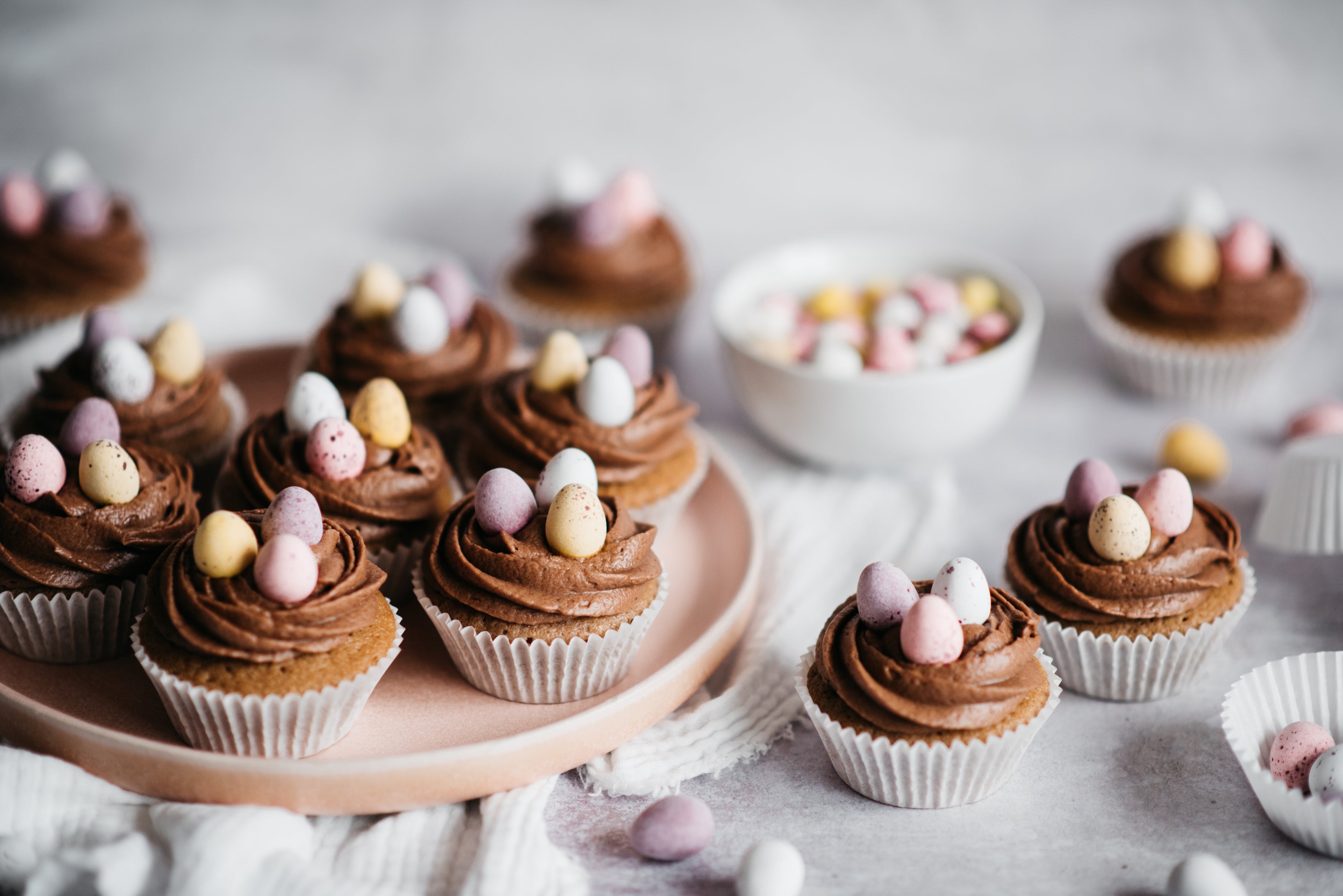 Batch of Easter chocolate cupcakes topped with swirls of chocolate icing and Cadbury's Mini Eggs