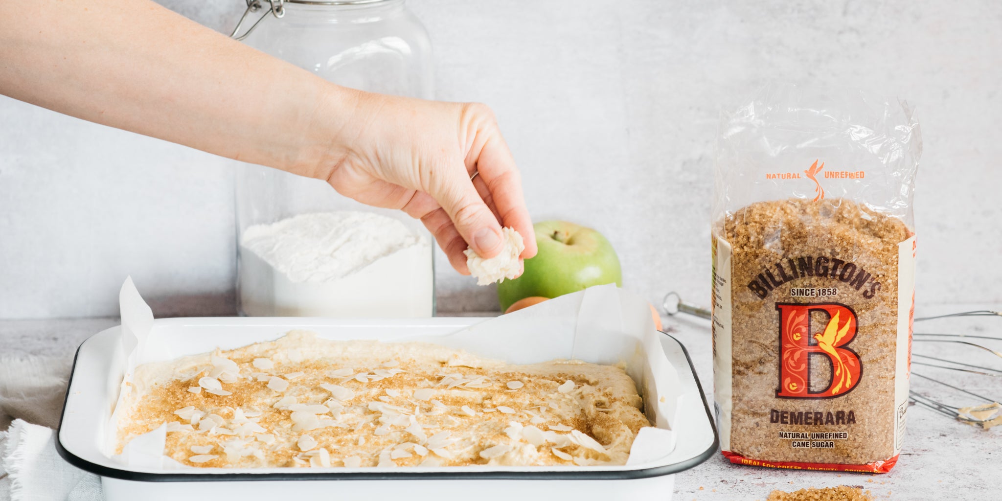 Hand sprinkling ingredients on top of cake batter