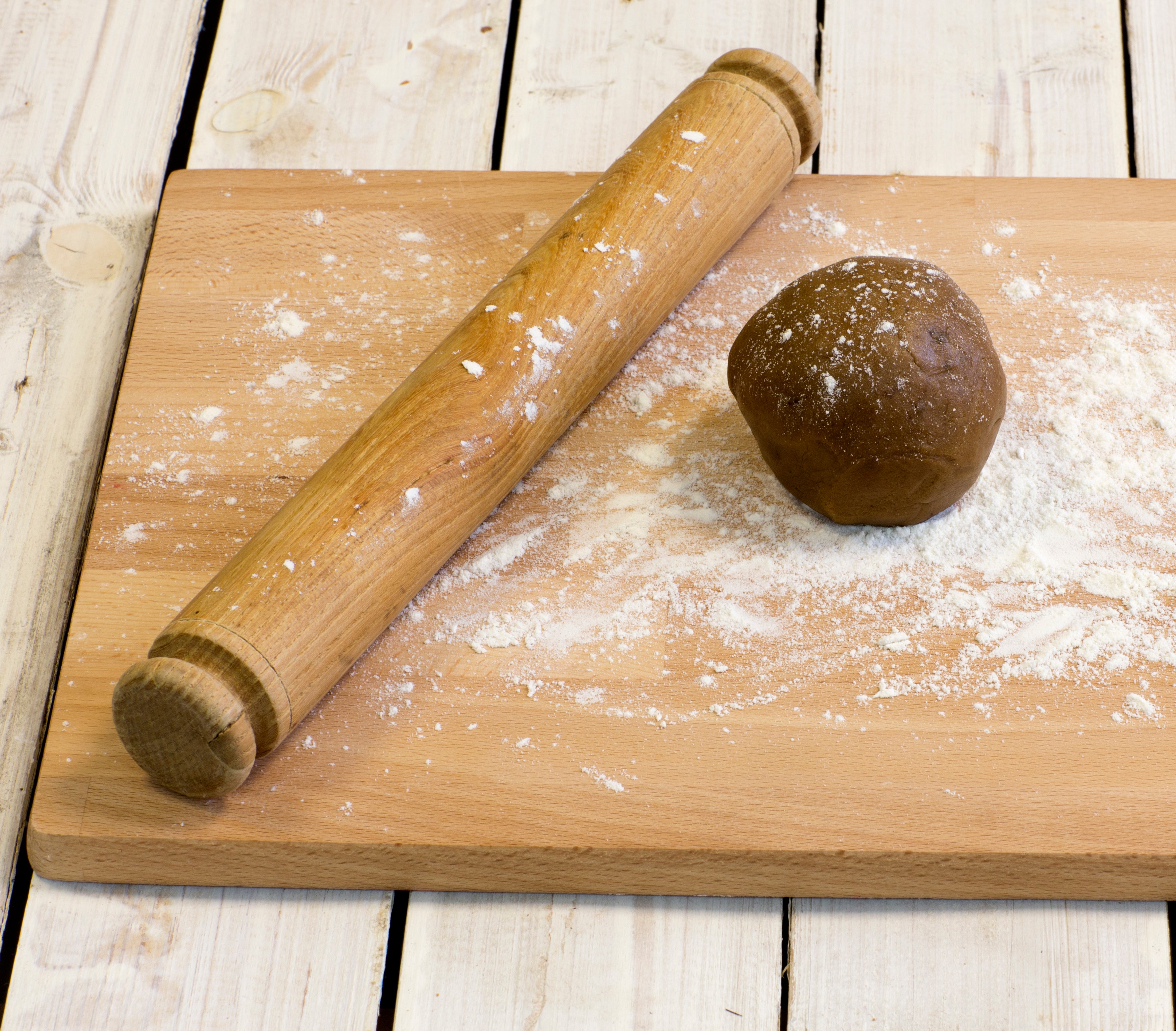 Rolling pin and ball of gingerbread dough on chopping board