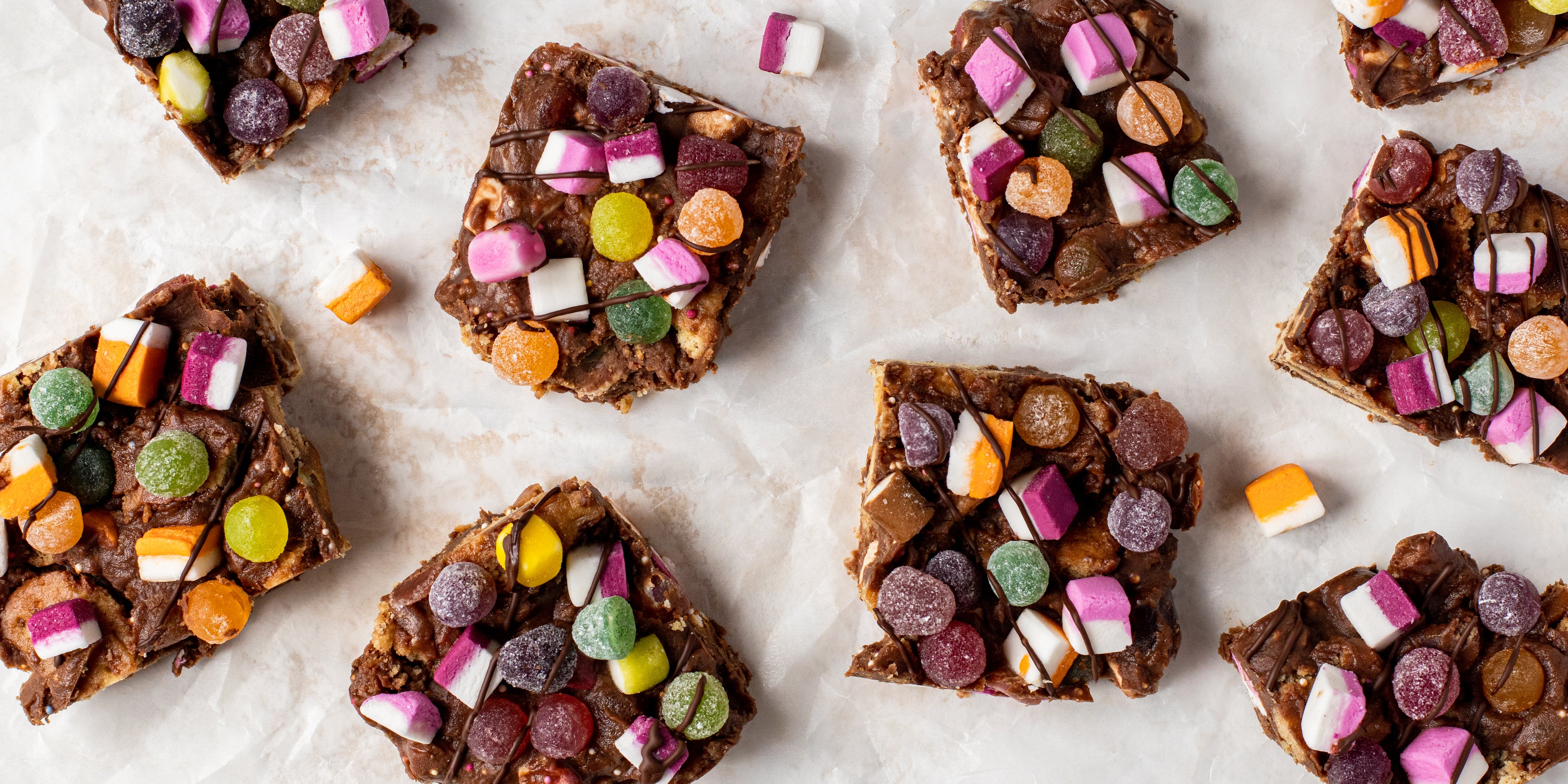 Top view of slices of Sweetie Rocky Road, topped with dolly mixture, and drizzled with chocolate