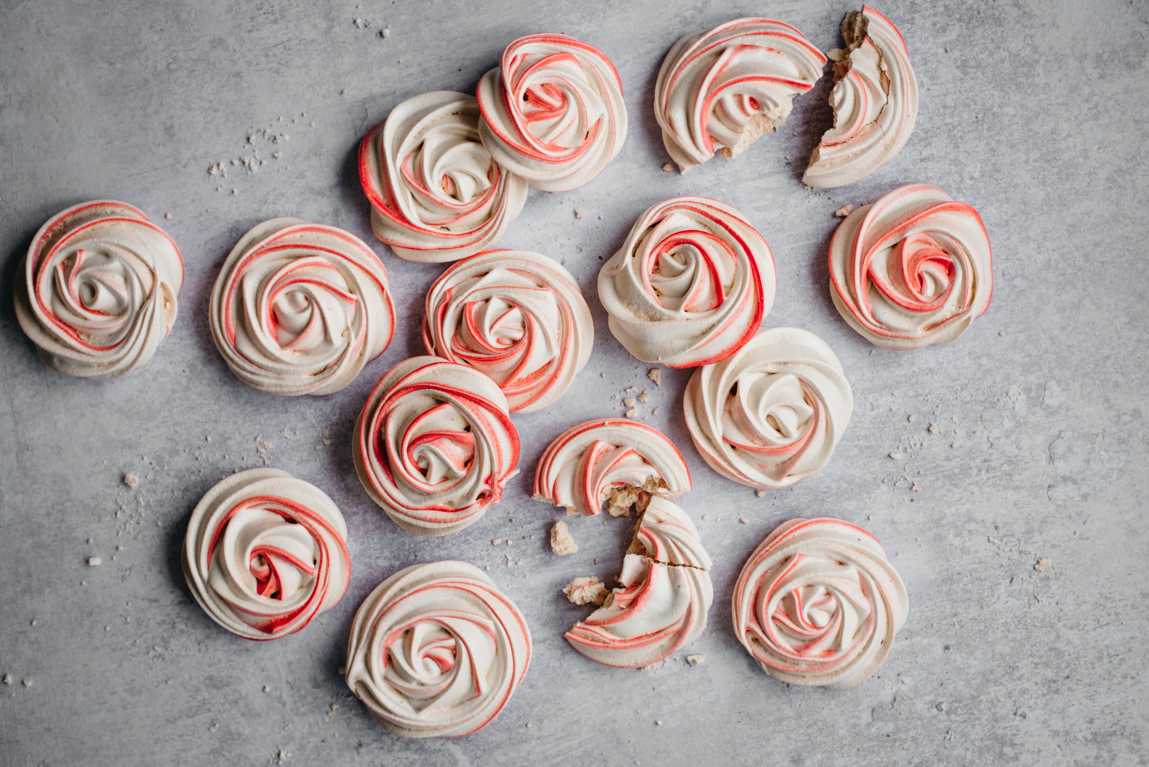 Top view of Vegan Meringue nests, cracked open with swirls of pink food colouring