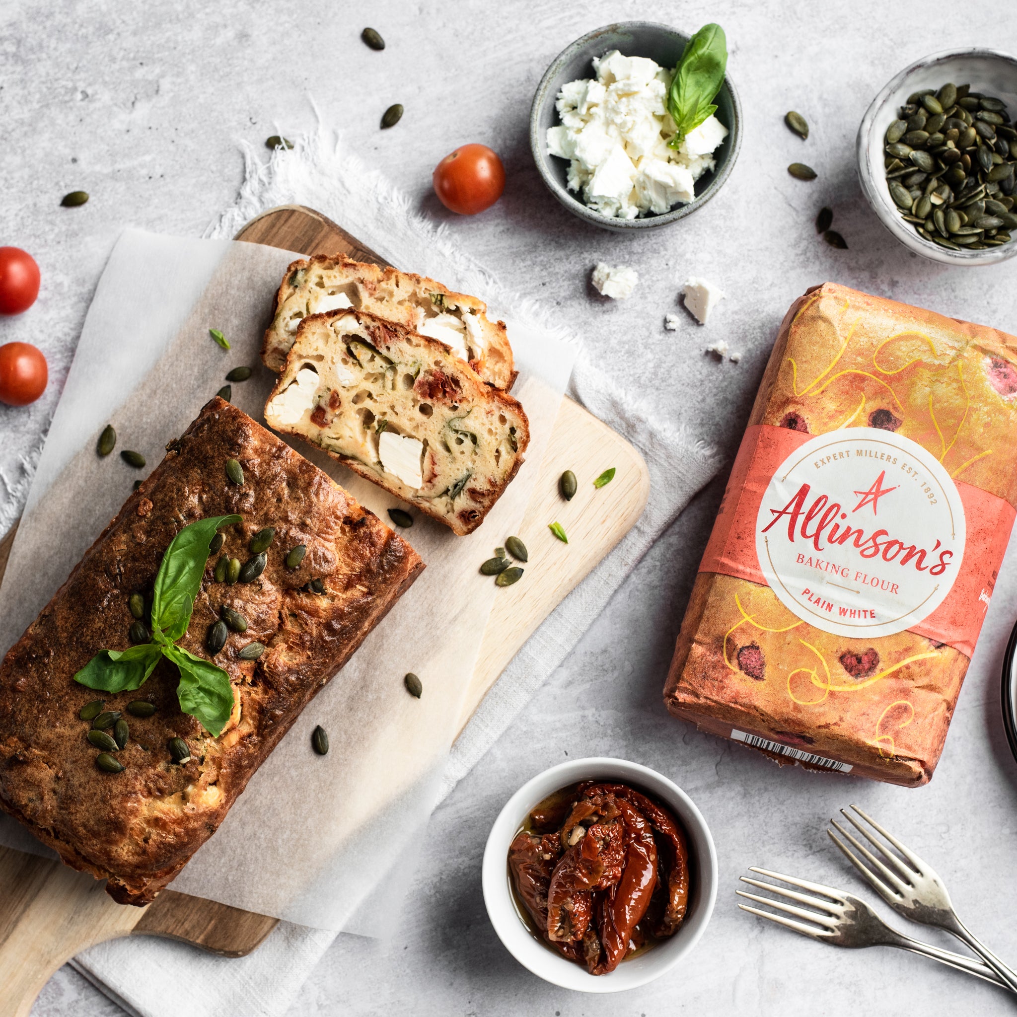 Feta and tomato loaf with slice removed on a chopping board