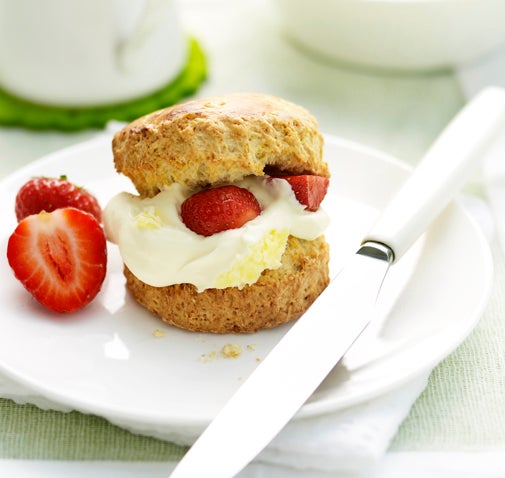 Buttermilk scones with whipped cream and sliced strawberries