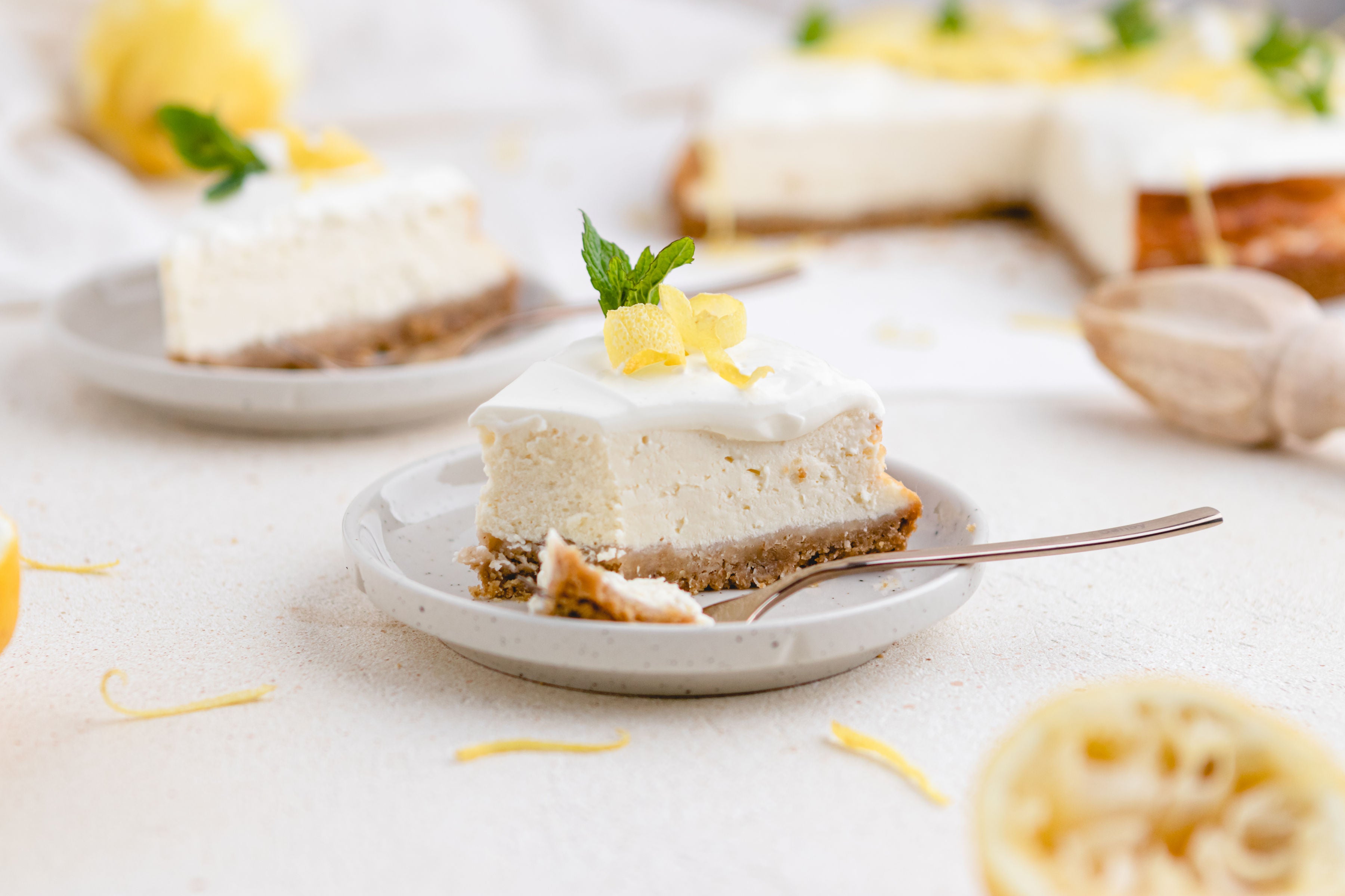 Close up shot of slice of lemon cheesecake on plate with fork