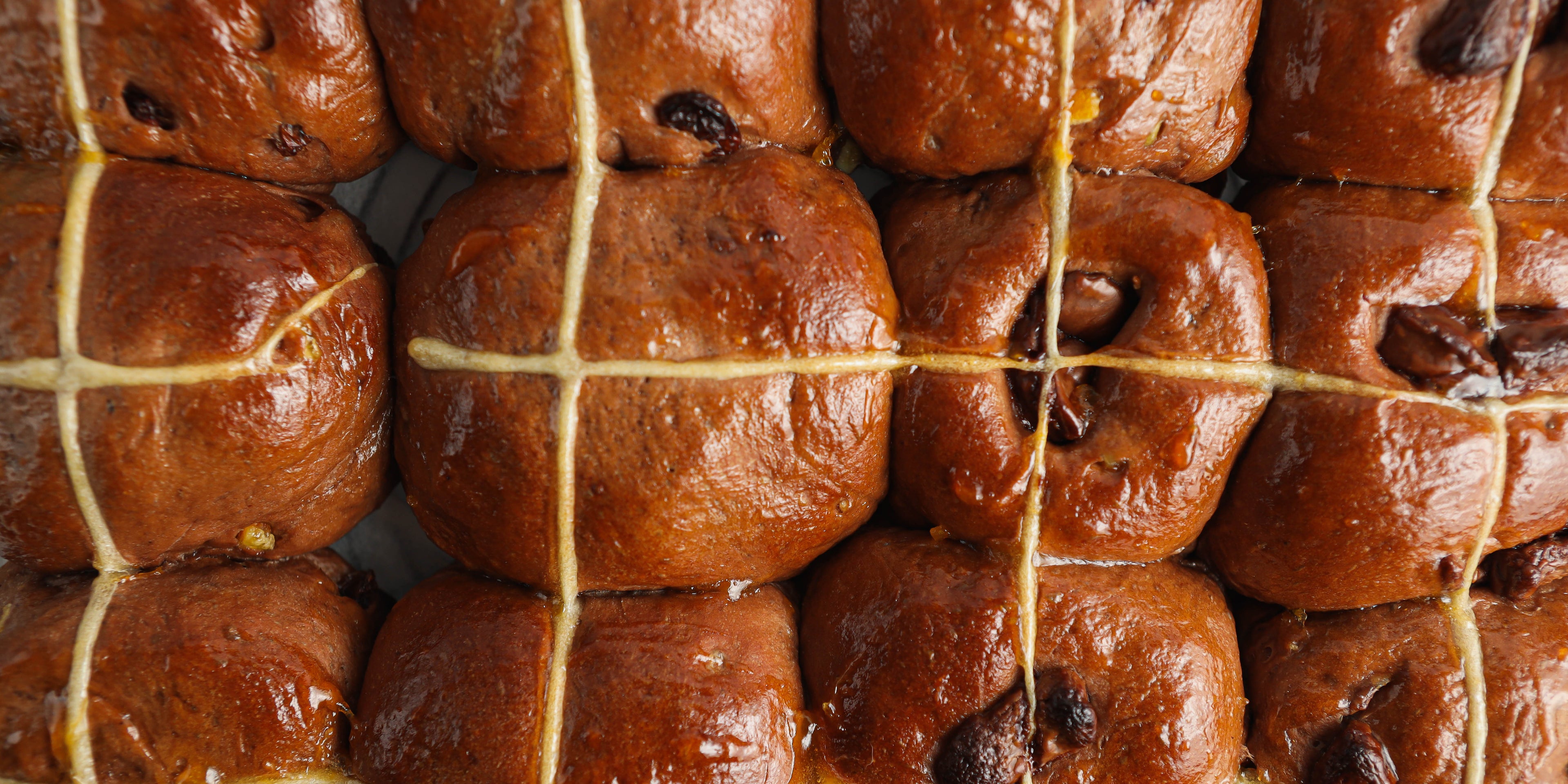 Close up of a batch of freshly-baked chocolate hot cross buns
