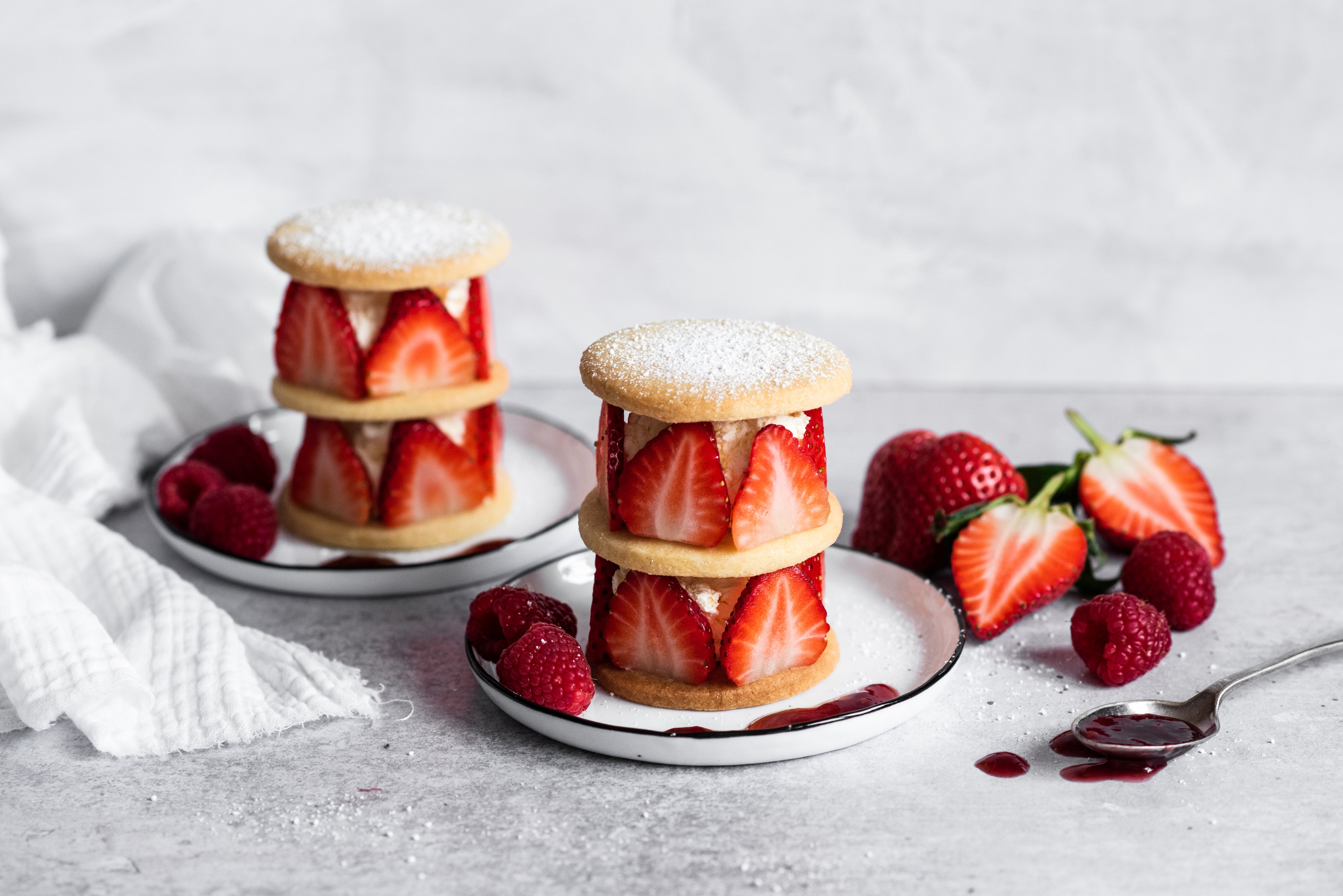 Shortbread rounds with sliced strawberries and cream sandwiched between