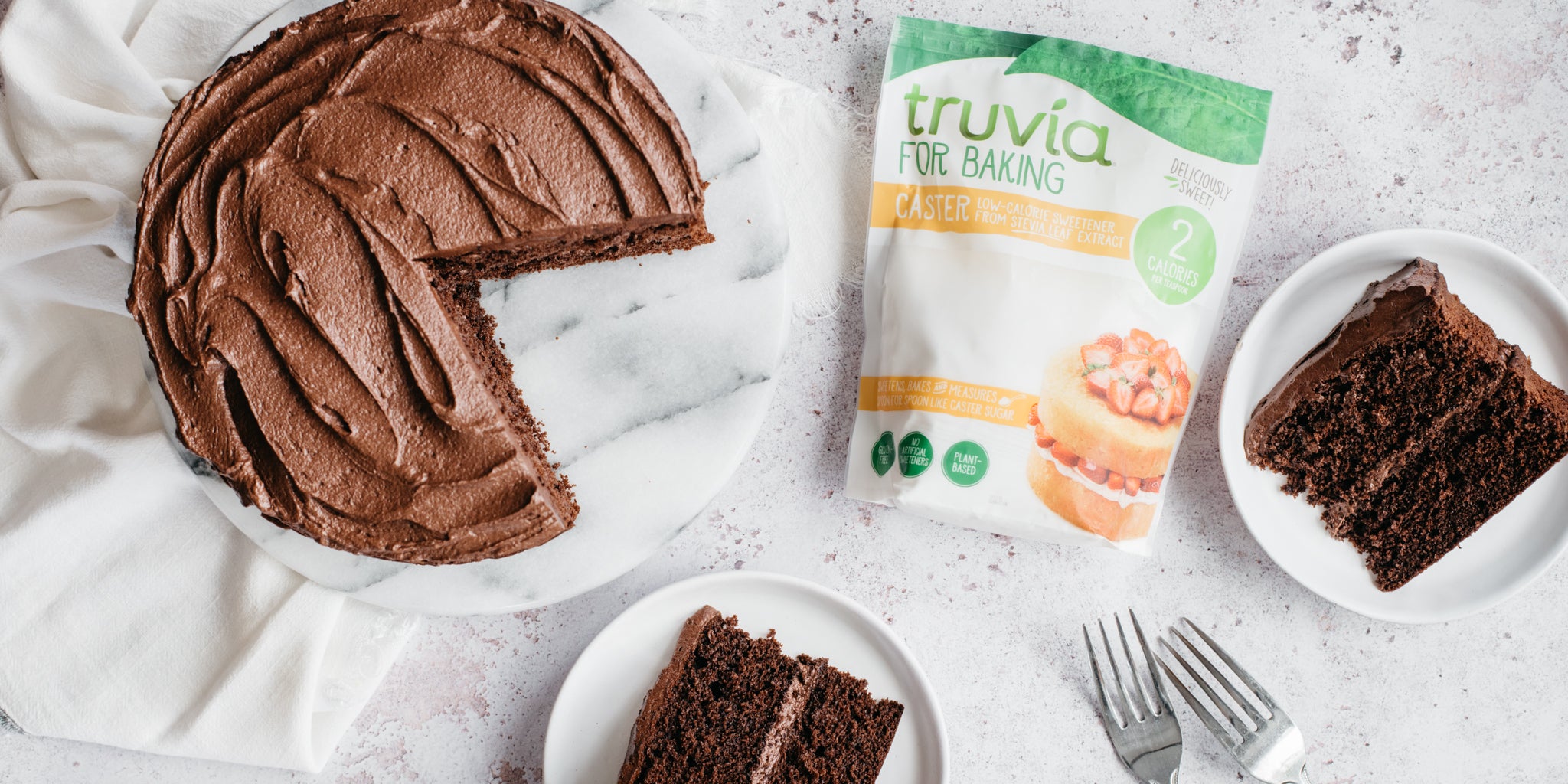 Top down shot of chocolate cake with truvia sweetener pack beside it and two slices of chocolate cake