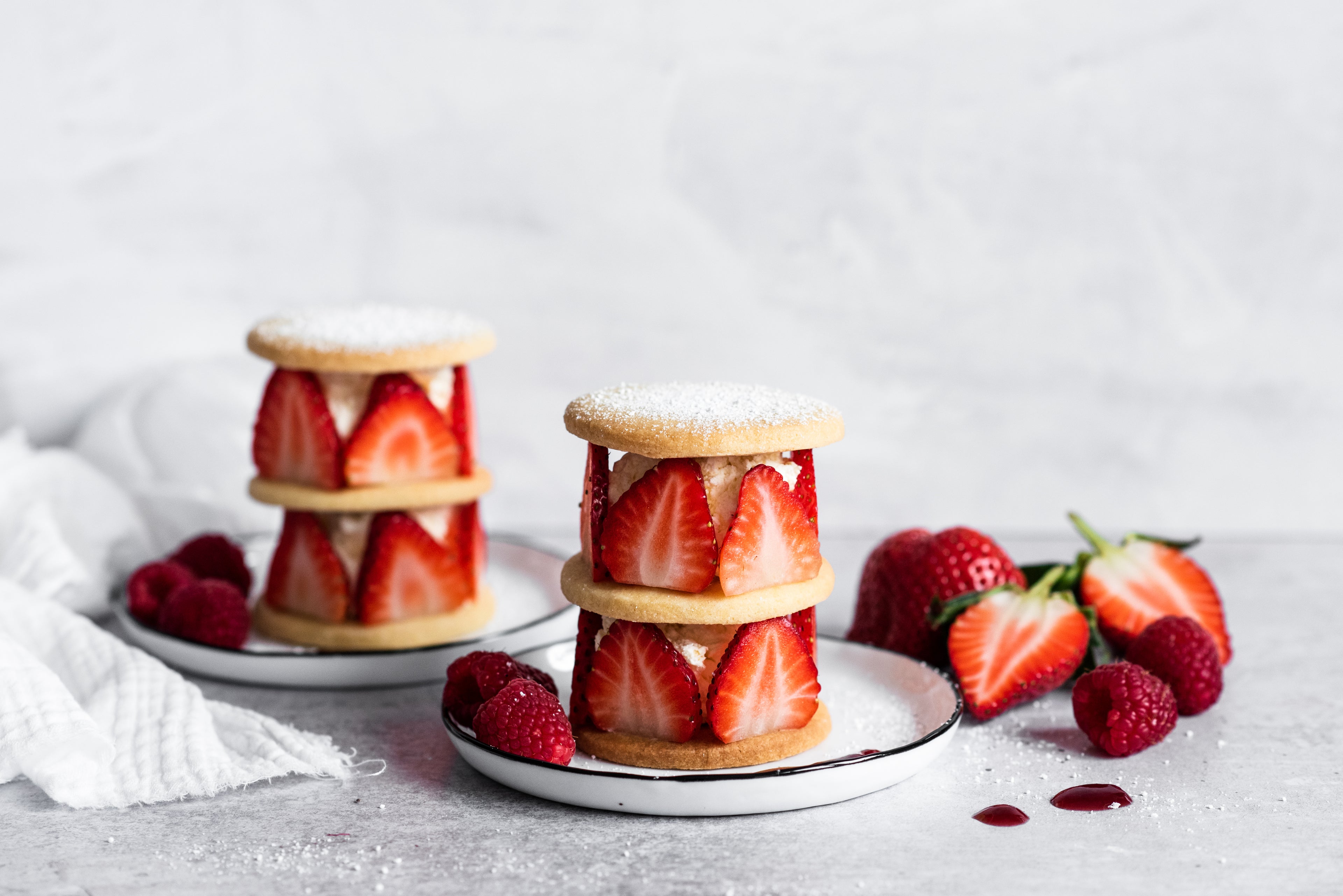 Shortbread rounds with sliced strawberries and cream sandwiched between