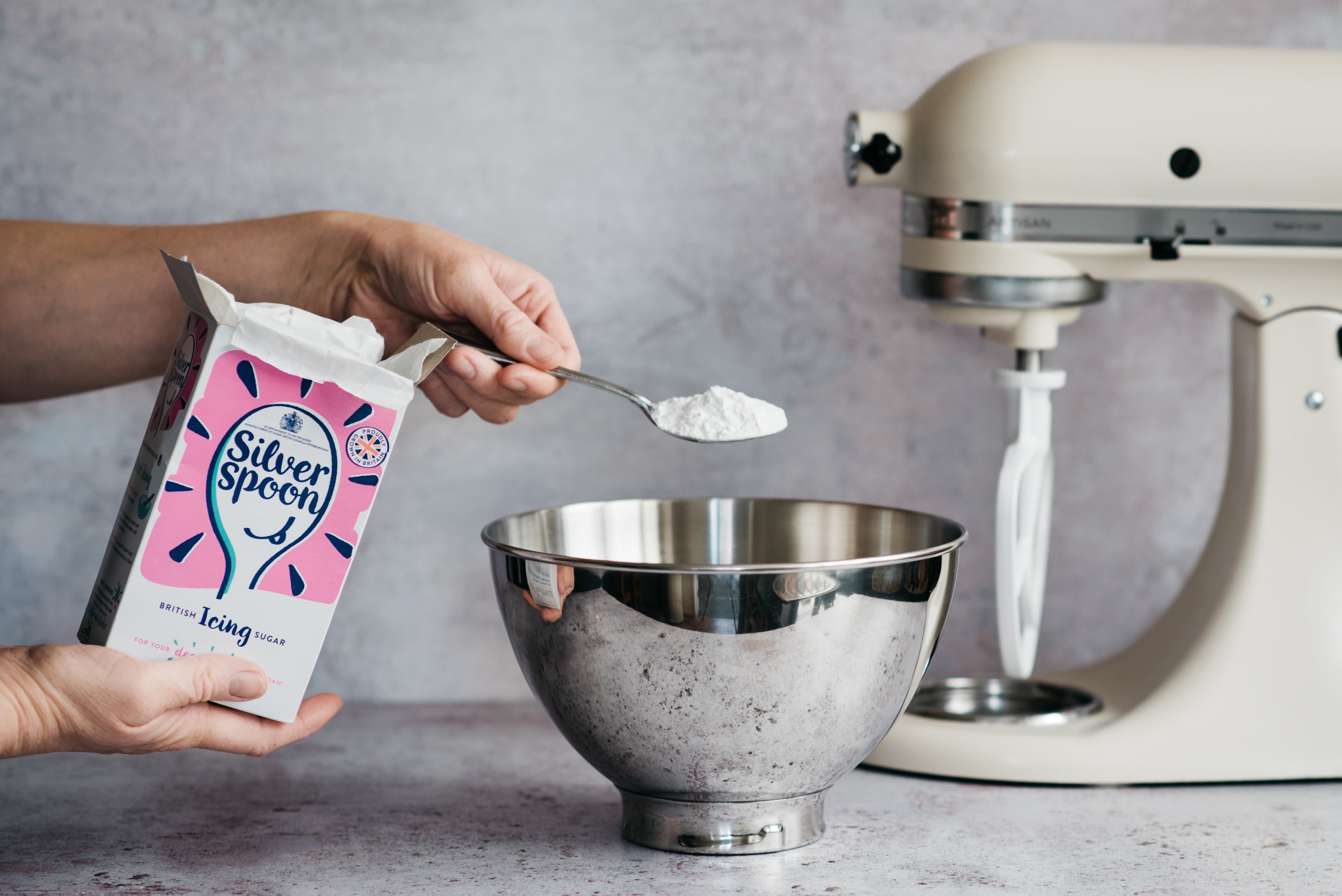 Hand sprinkling Silver Spoon Icing Sugar into a stand mixer to make buttercream for the Gluten Free Elderflower & Lemon Cake