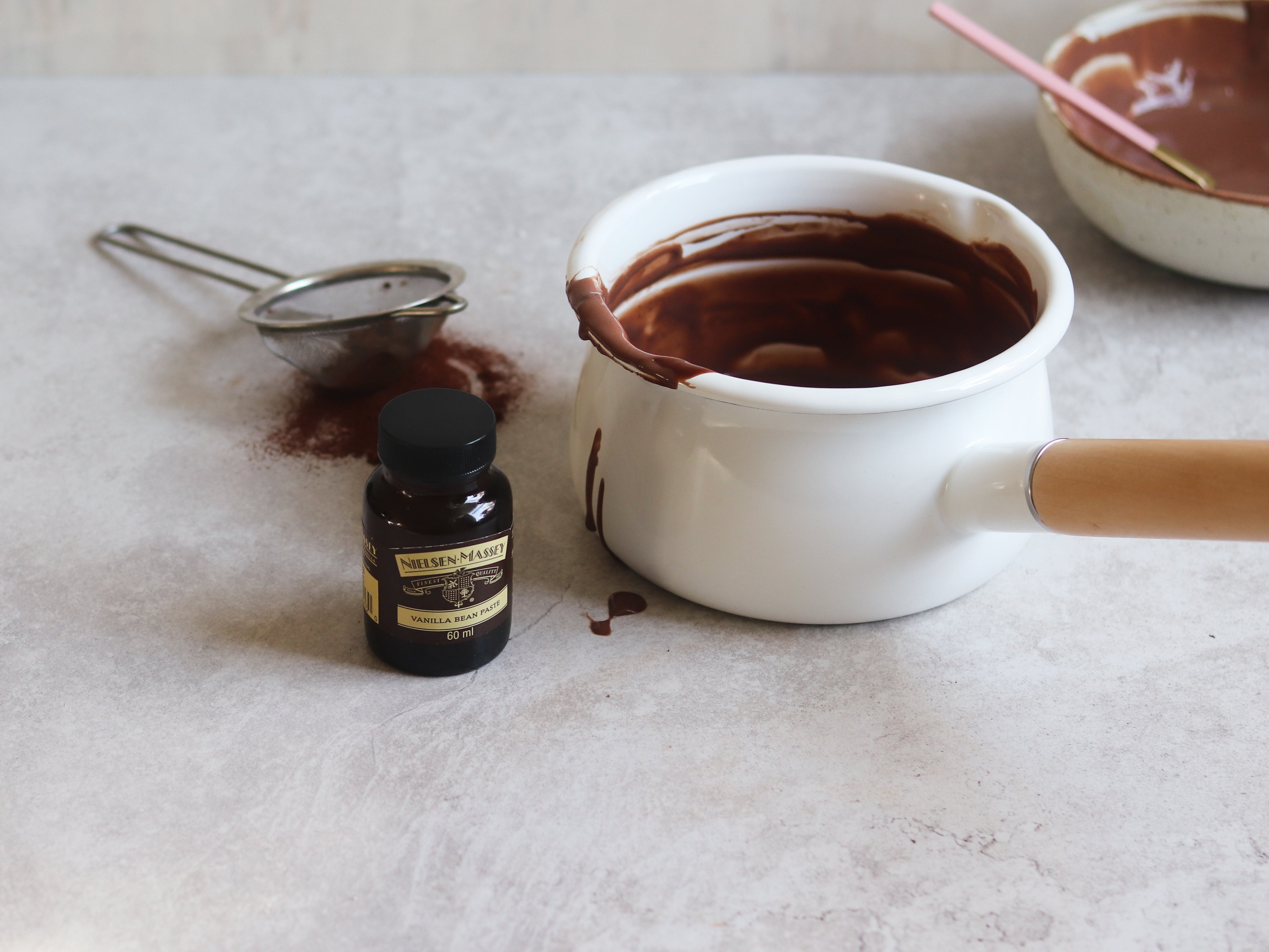 Saucepan of Chocolate Custard next to a bottle of Neilsen-Massey custard