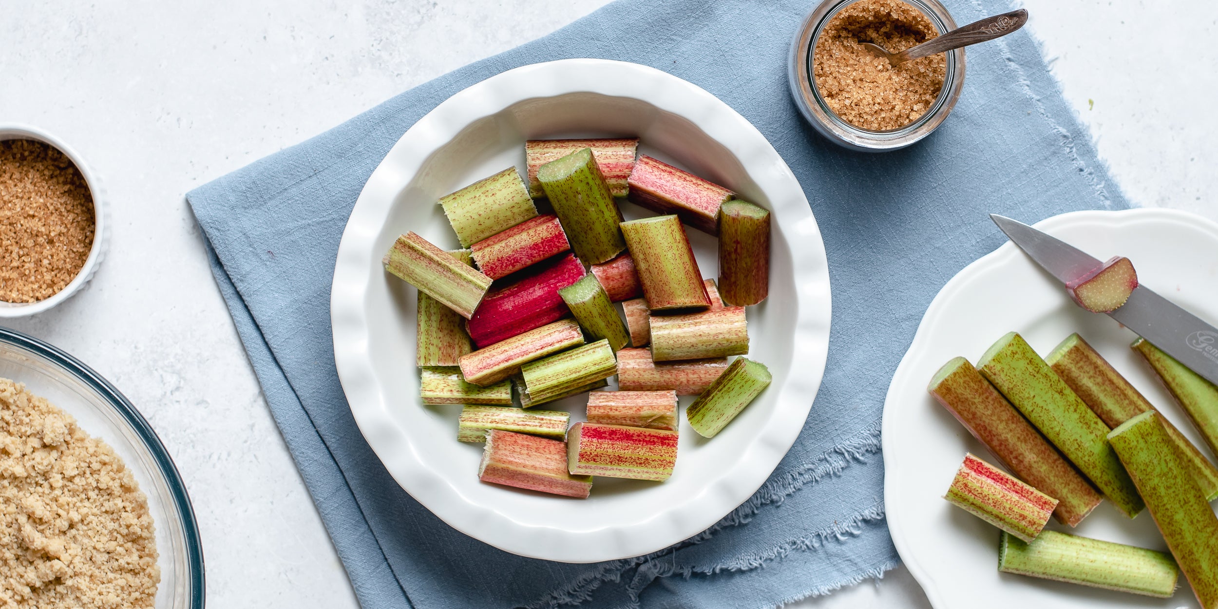 Fresh rhubarb chopped into the base of a pie dish for a Rhubarb Crumble