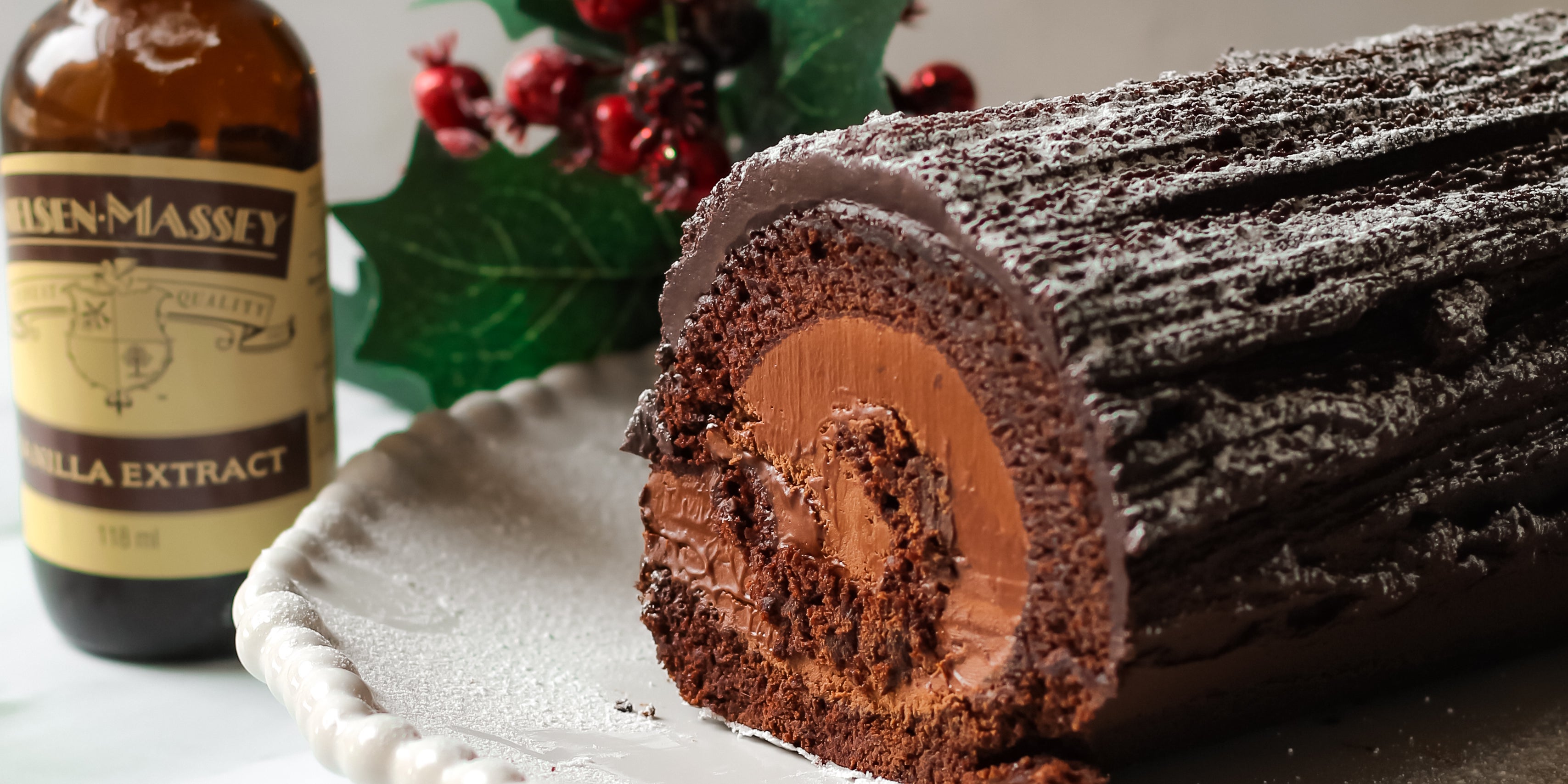 Close up of Vegan Yule Log next to a bottle of Neilsen-Massey Vanilla Extract