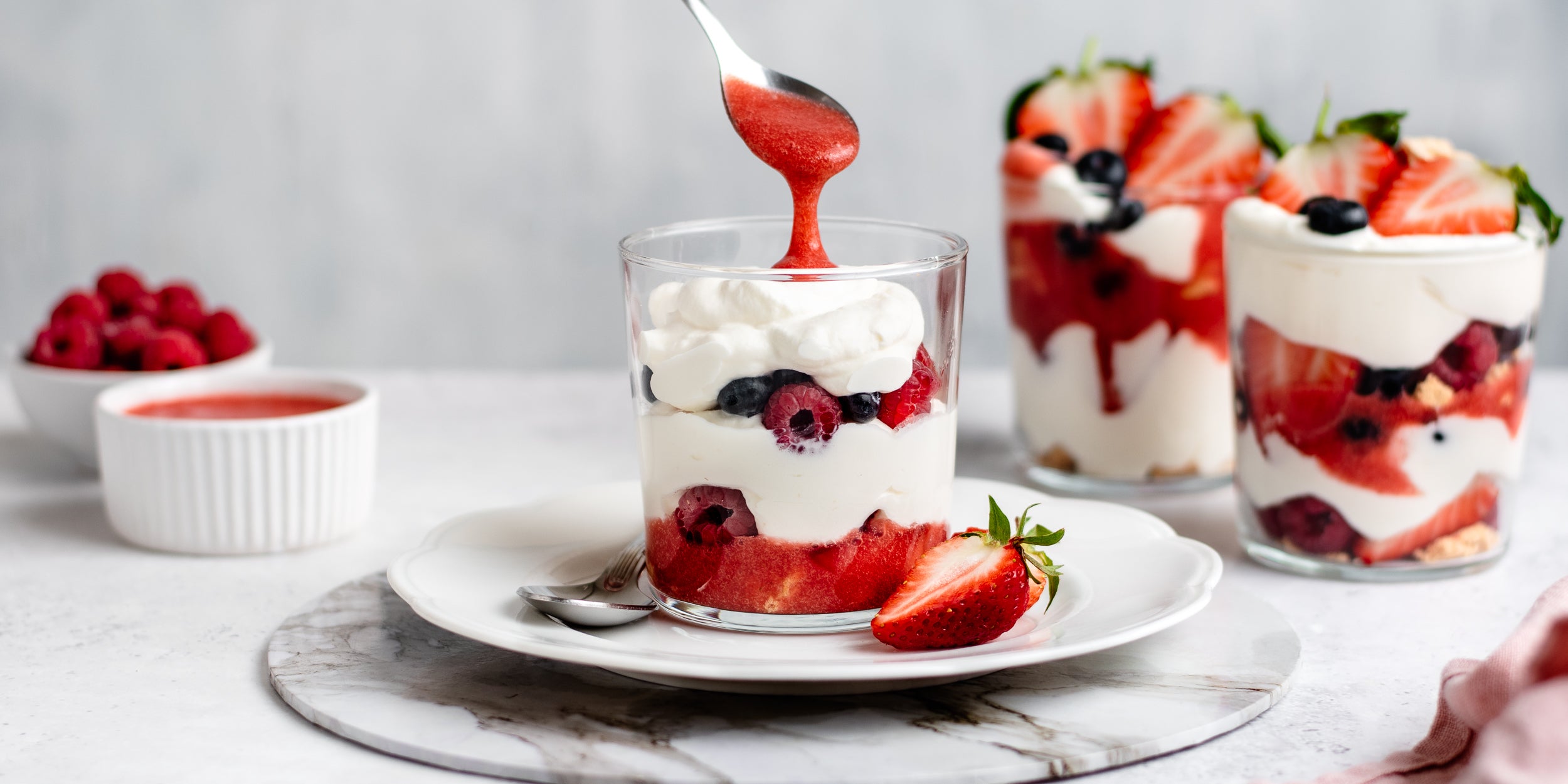 Summer Berry Eton Mess being drizzled with strawberry puree