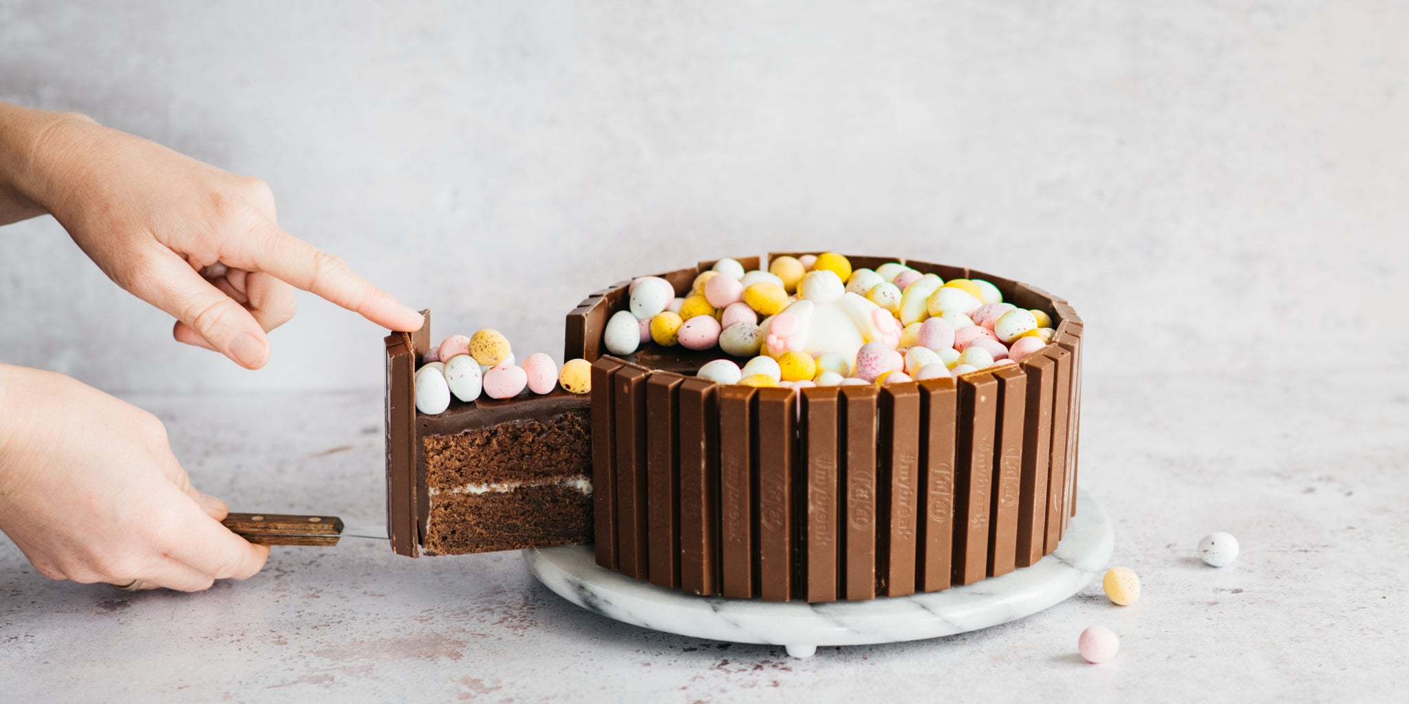 Chocolate easter cake with hand removing a slice from it 