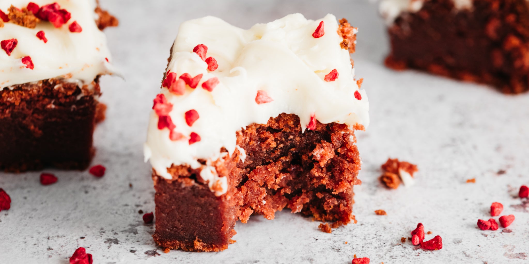 Square of red velvet traybake with a bite taken out of it