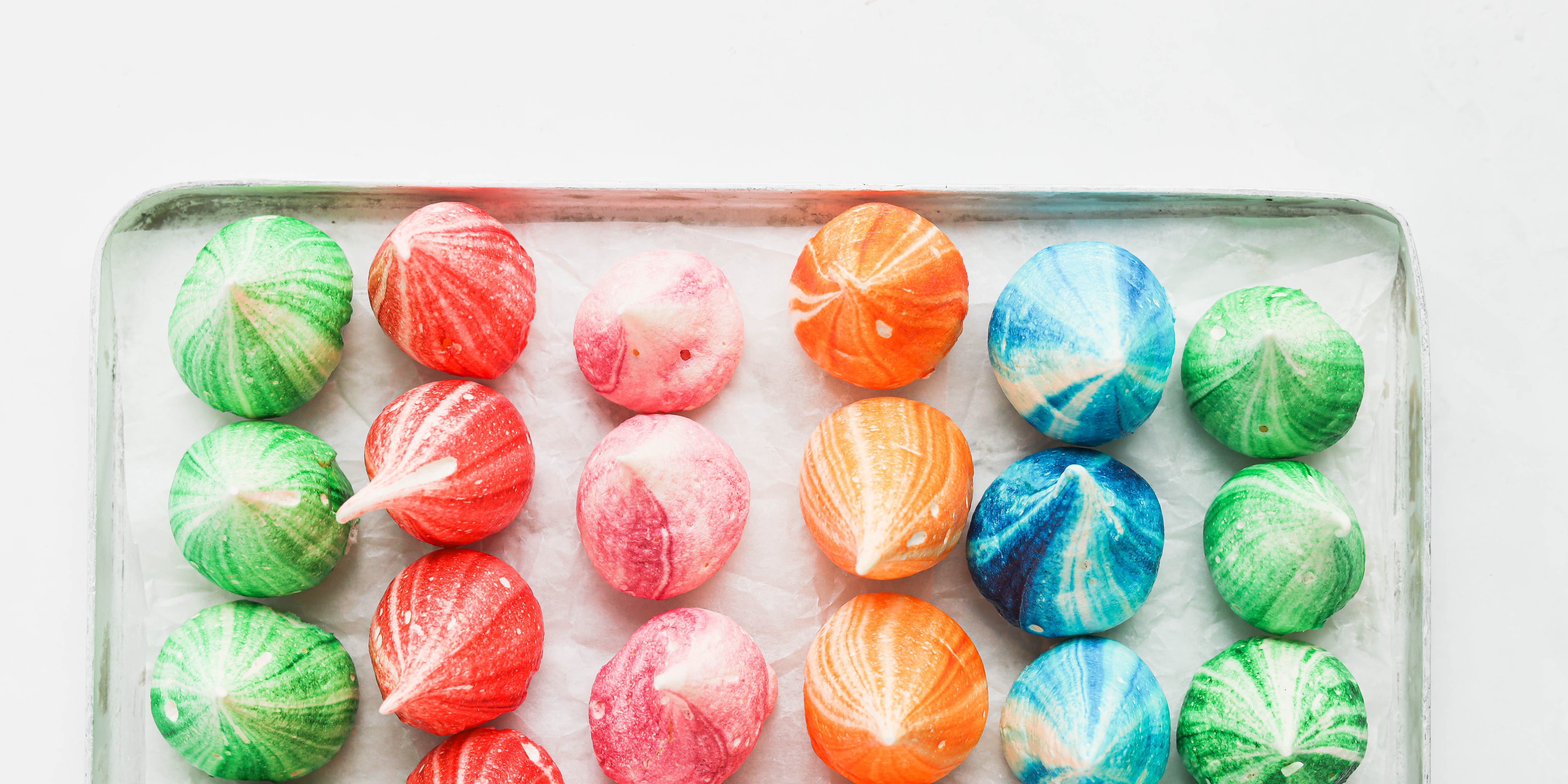 Small coloured meringue kisses in lines of 3 coloured green, red, pink, orange and blue