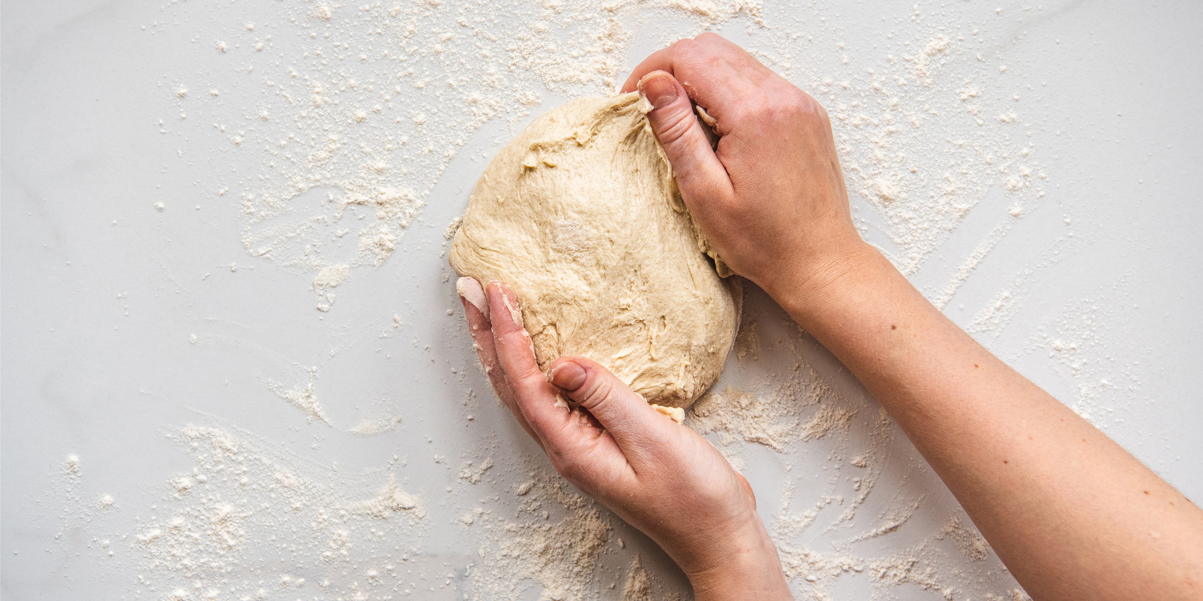 Top down view of hands kneading dough