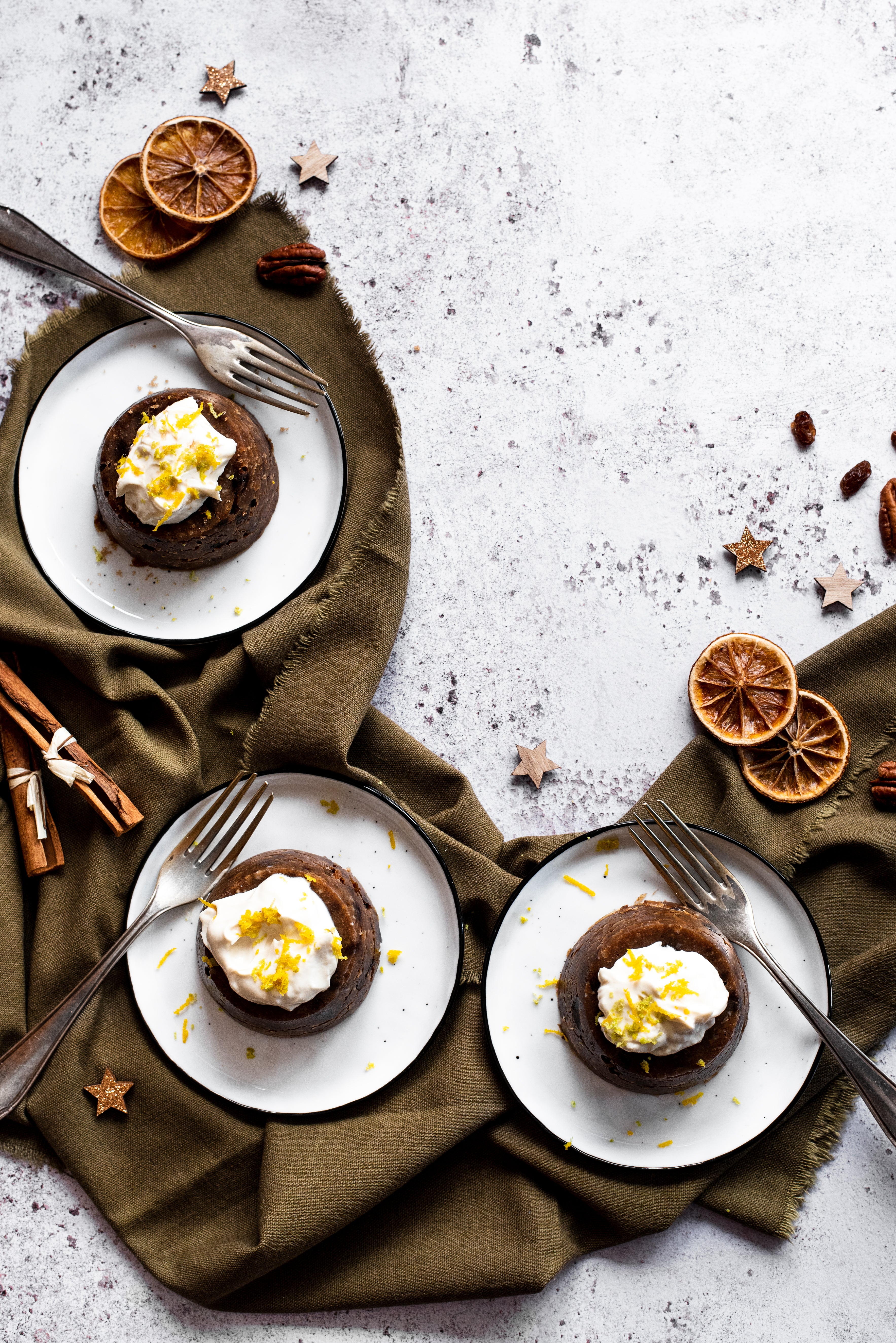 3 mini Christmas puddings on plates with forks