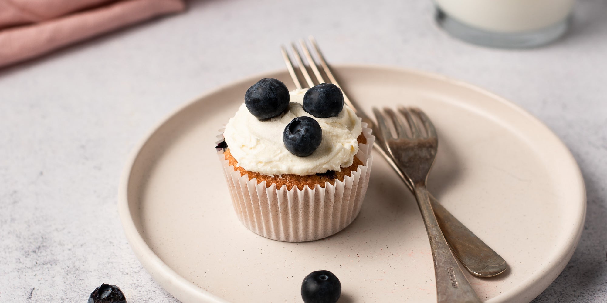 Cupcakes topped with icing and blueberries