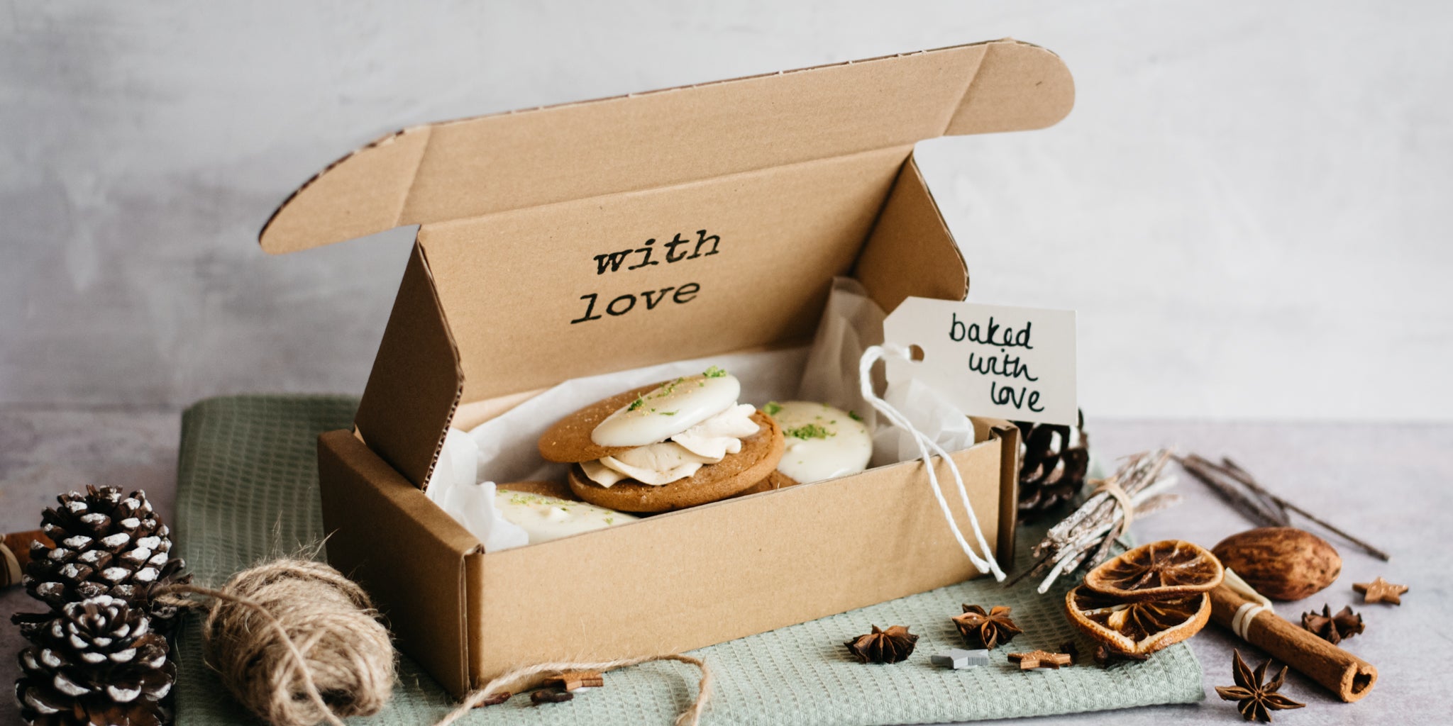 Citrus Gingerbread Cookies being packed into a gfit box to give to a friend at Christmas. Next to a hand written note, and a collection of Christmas decorations