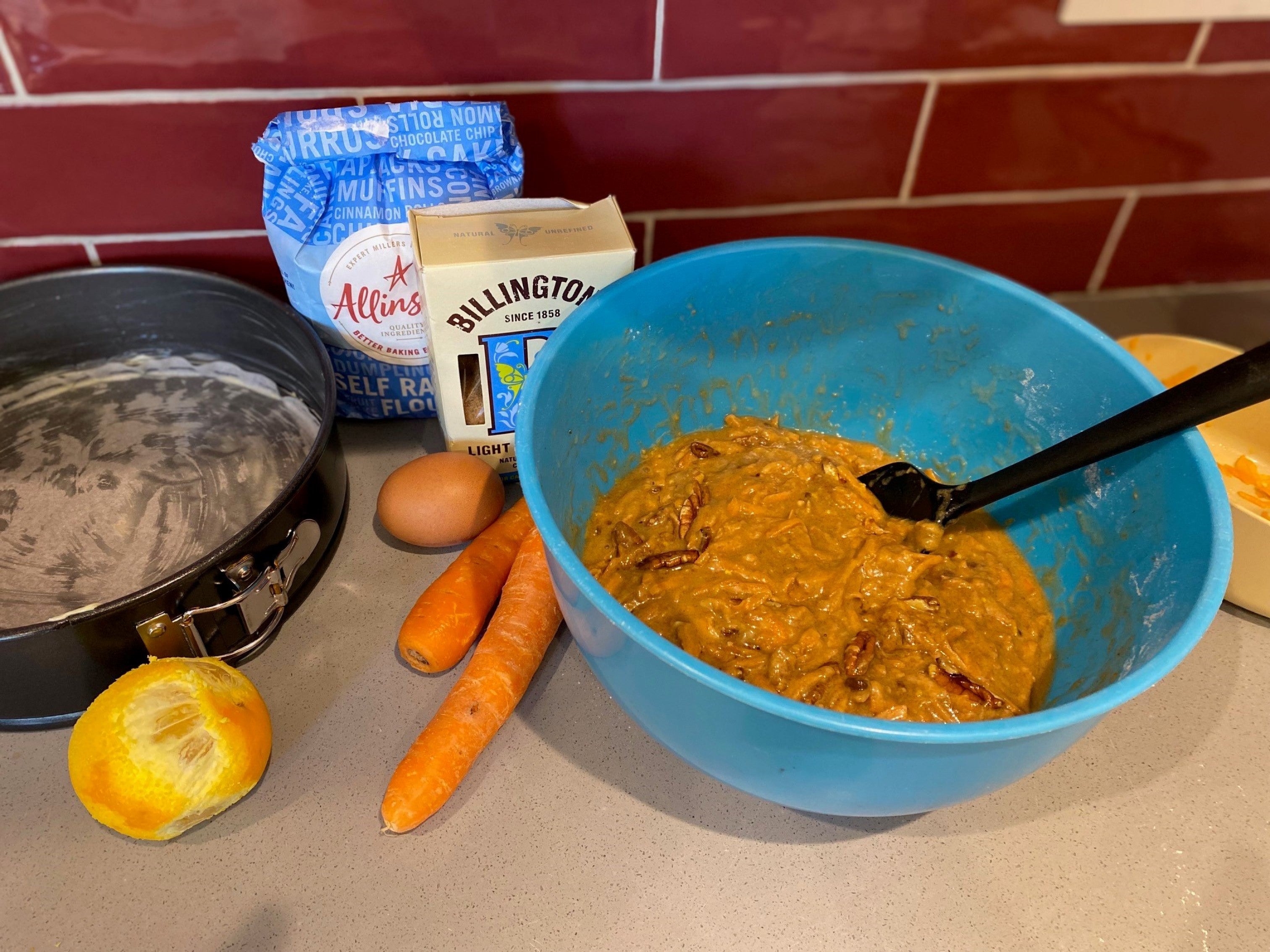 Mixing the ingredients for Paul Hollywood's carrot cake in a blue bowl