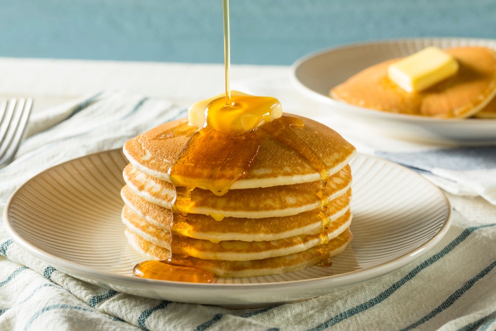 Stack of low-carb keto pancakes topped with butter on a plate