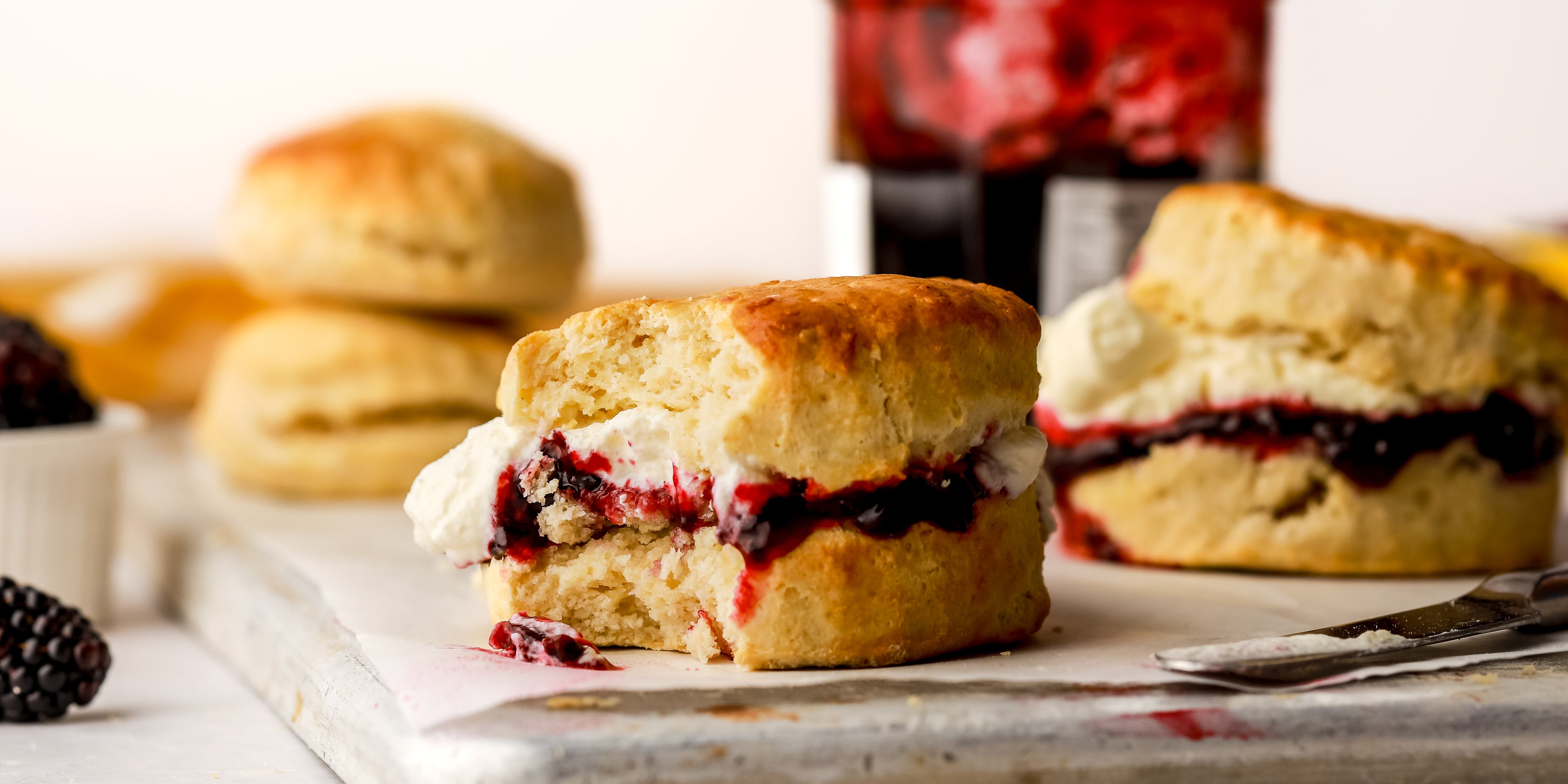 Scone with cream and jam in centre and a bite taken out of it