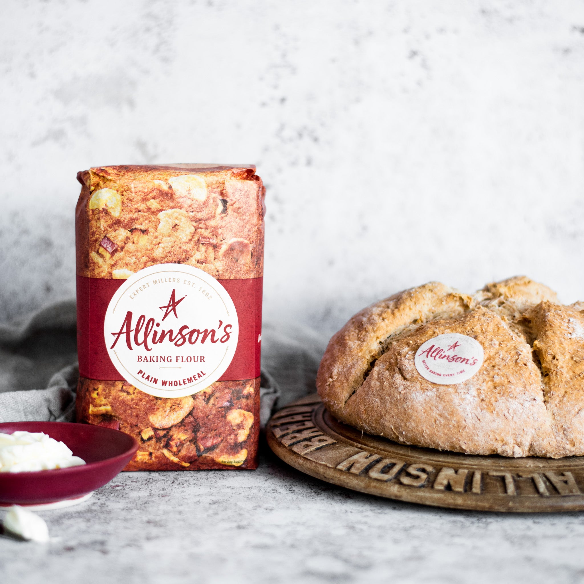 Soda Bread loaf on a wooden board next to a bag of Allinson's flour