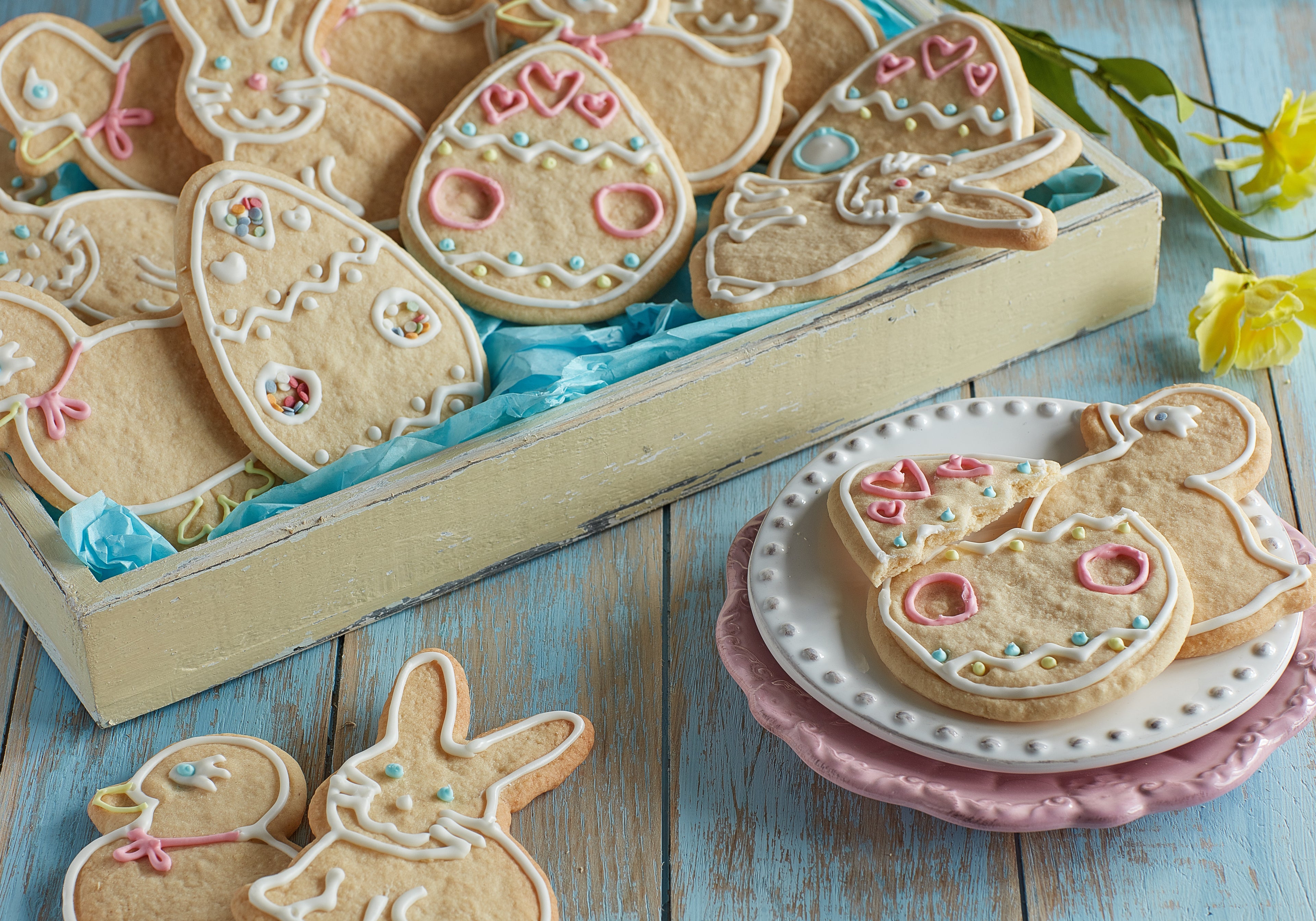 Easter Biscuits in a box with a few on a plate in the forefront