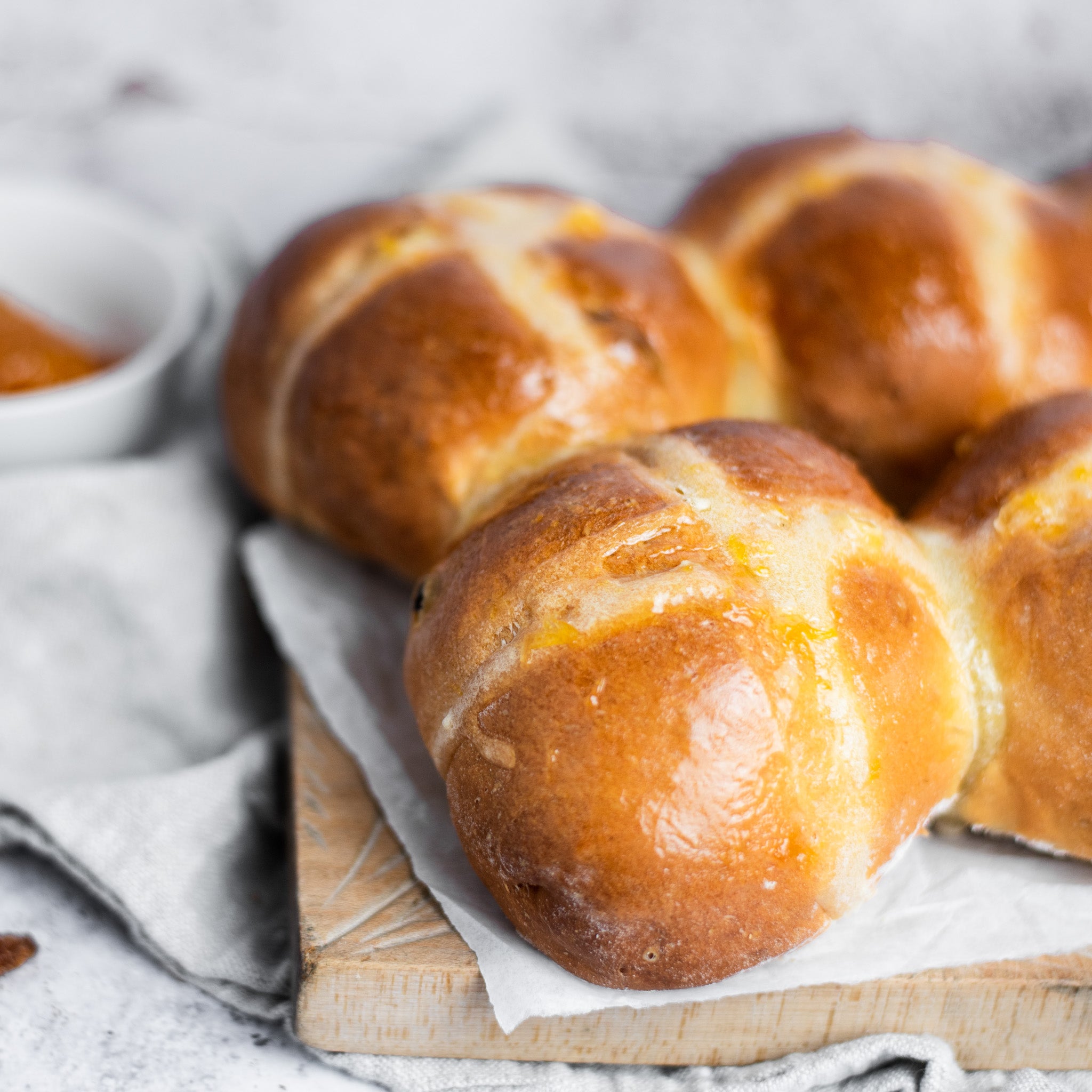 Close-up of a hot cross bun with a sweet apricot glaze